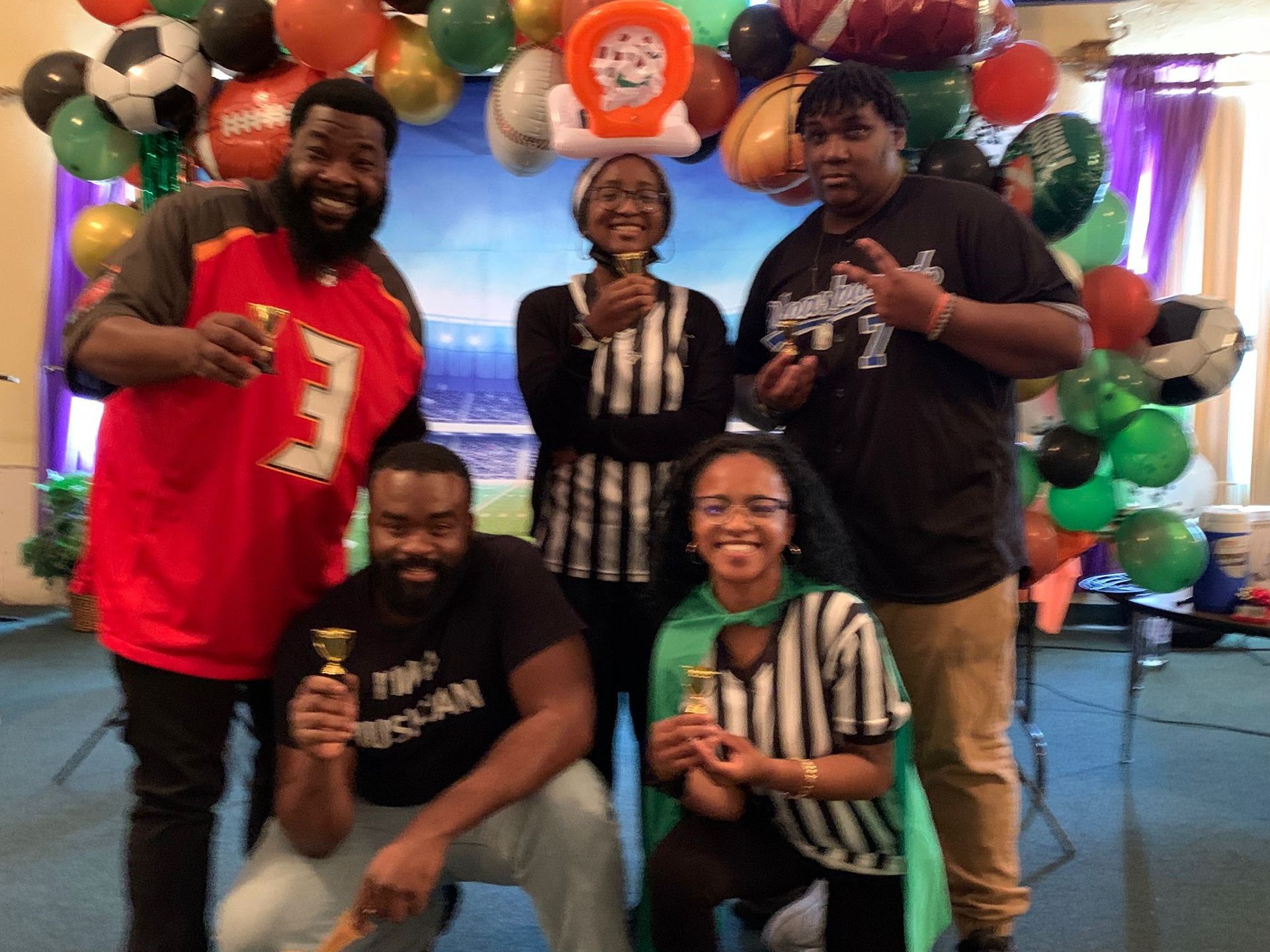 A group of people posing for a picture with balloons in the background