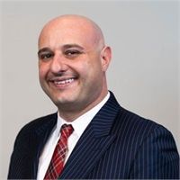 A man in a suit and tie is smiling for the camera.