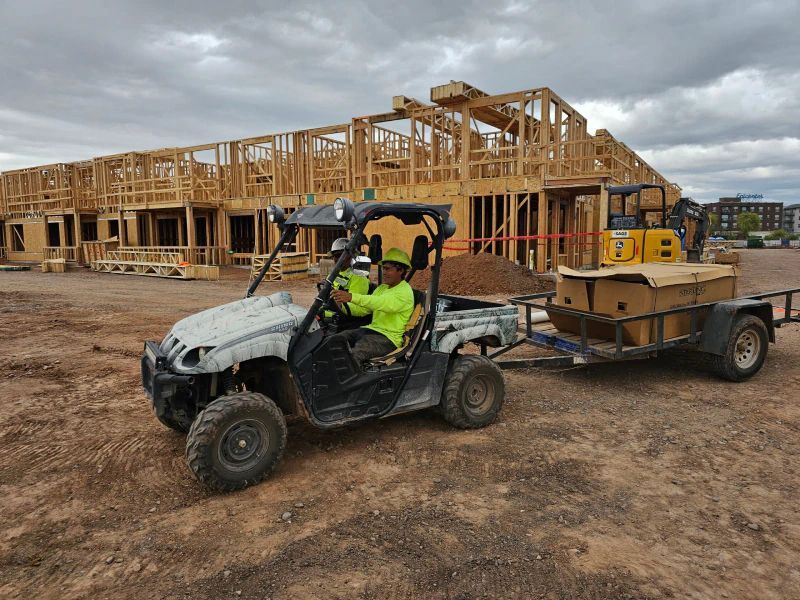 A Man Is Driving A ATV With A Trailer Attached To It