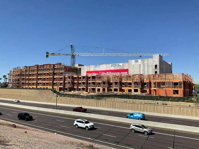 A Large Building Is Being Built Next To A Highway