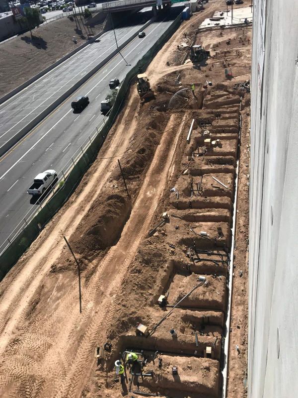 An Aerial View Of A Construction Site With A Highway In The Background