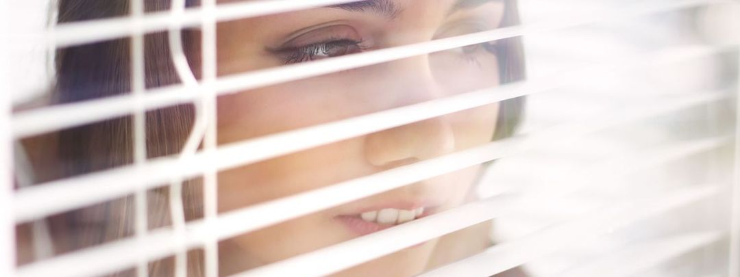 Waikato lady looks through blinds