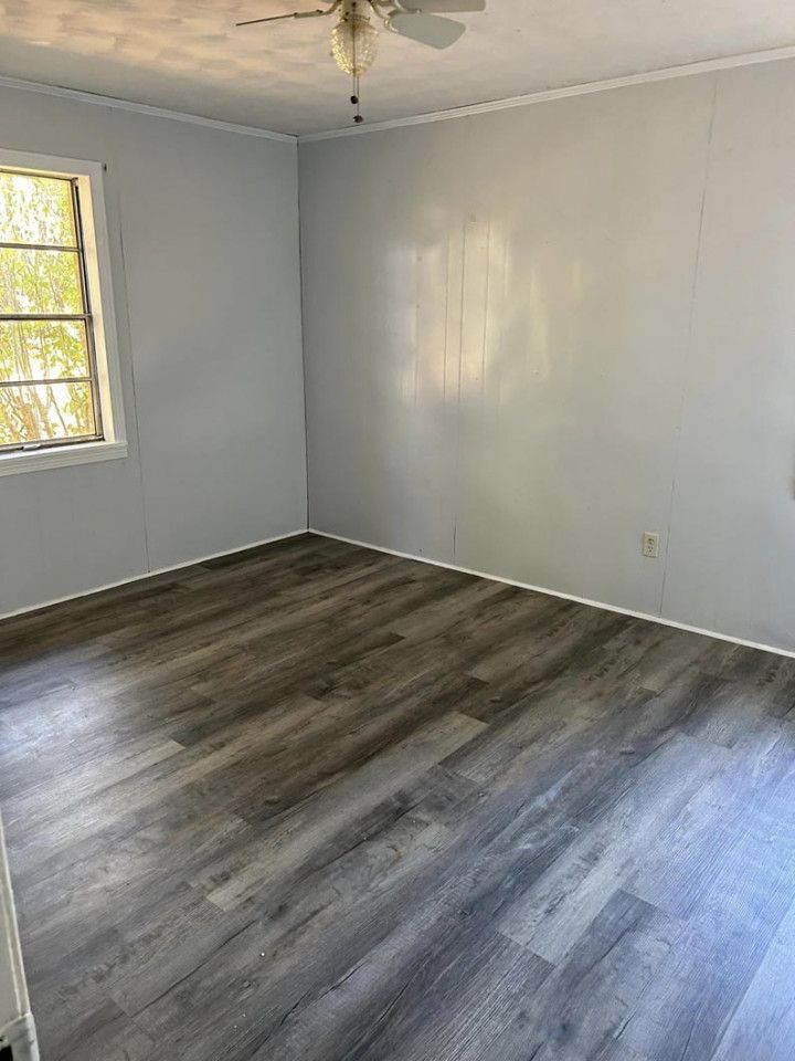 an empty room with hardwood floors and a ceiling fan .