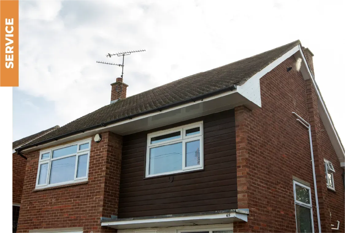 A brick house with a roof that has a satellite dish on top of it.