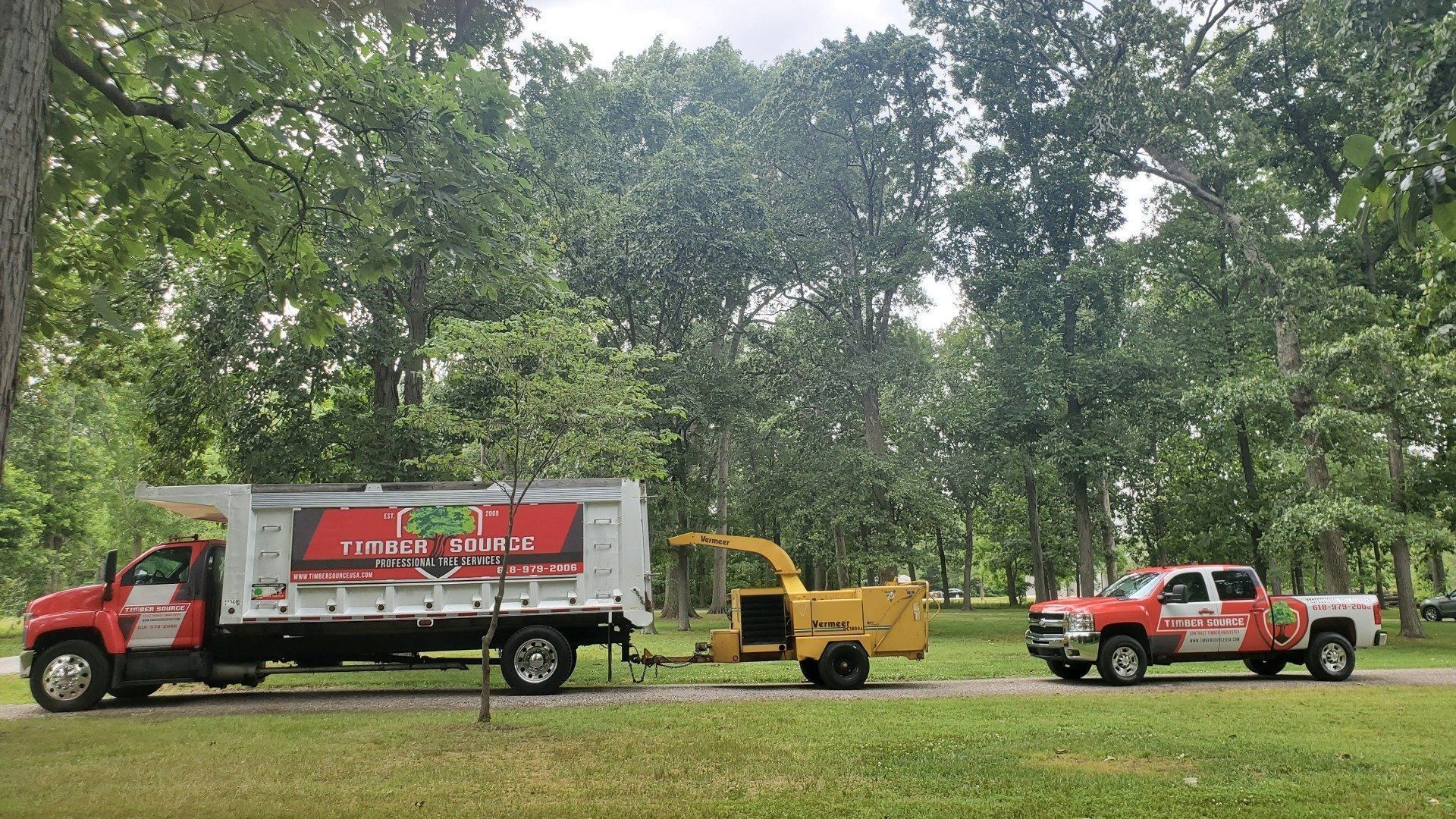 Two trucks are parked next to each other in a park.