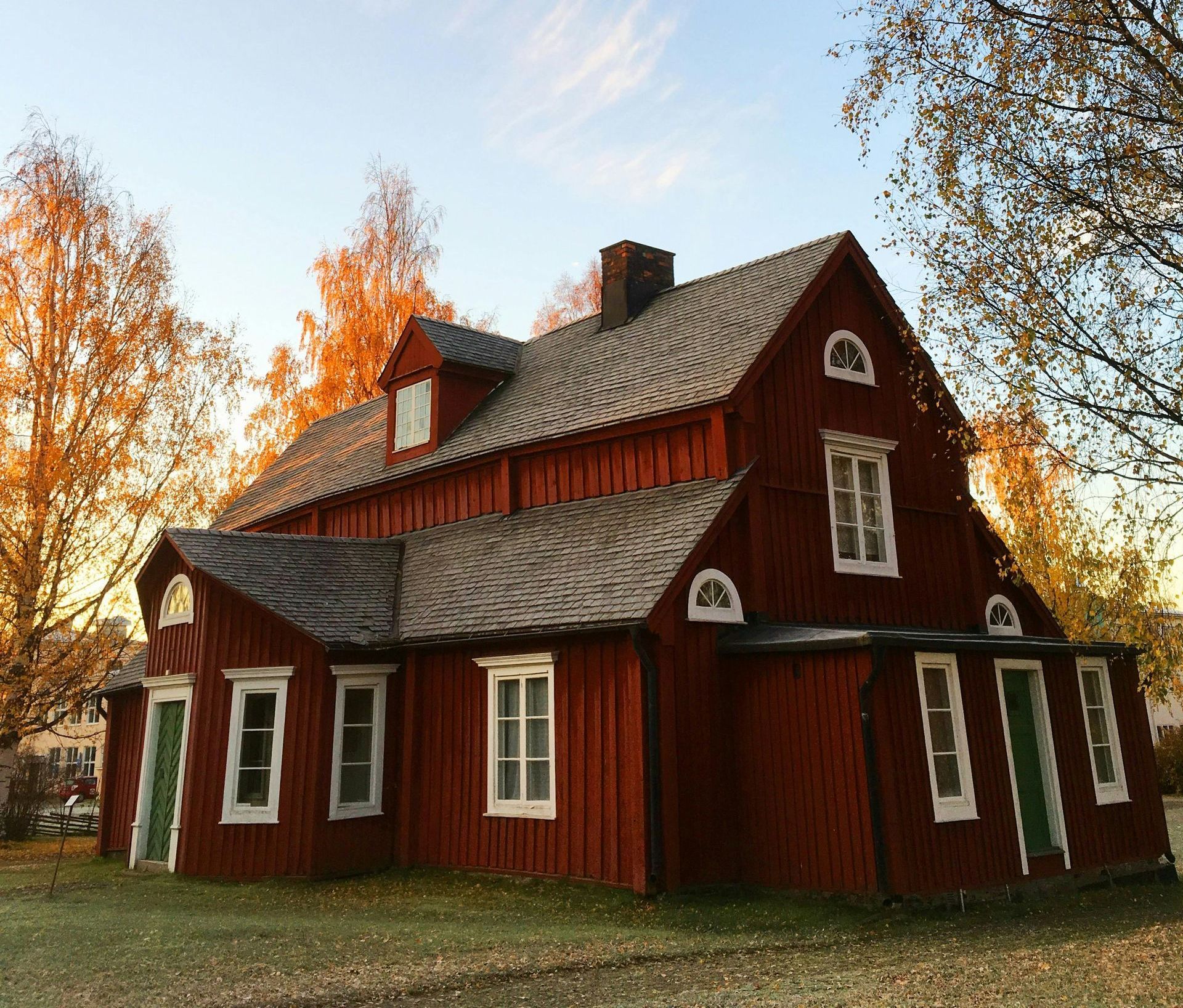A red house with a gray roof and white windows