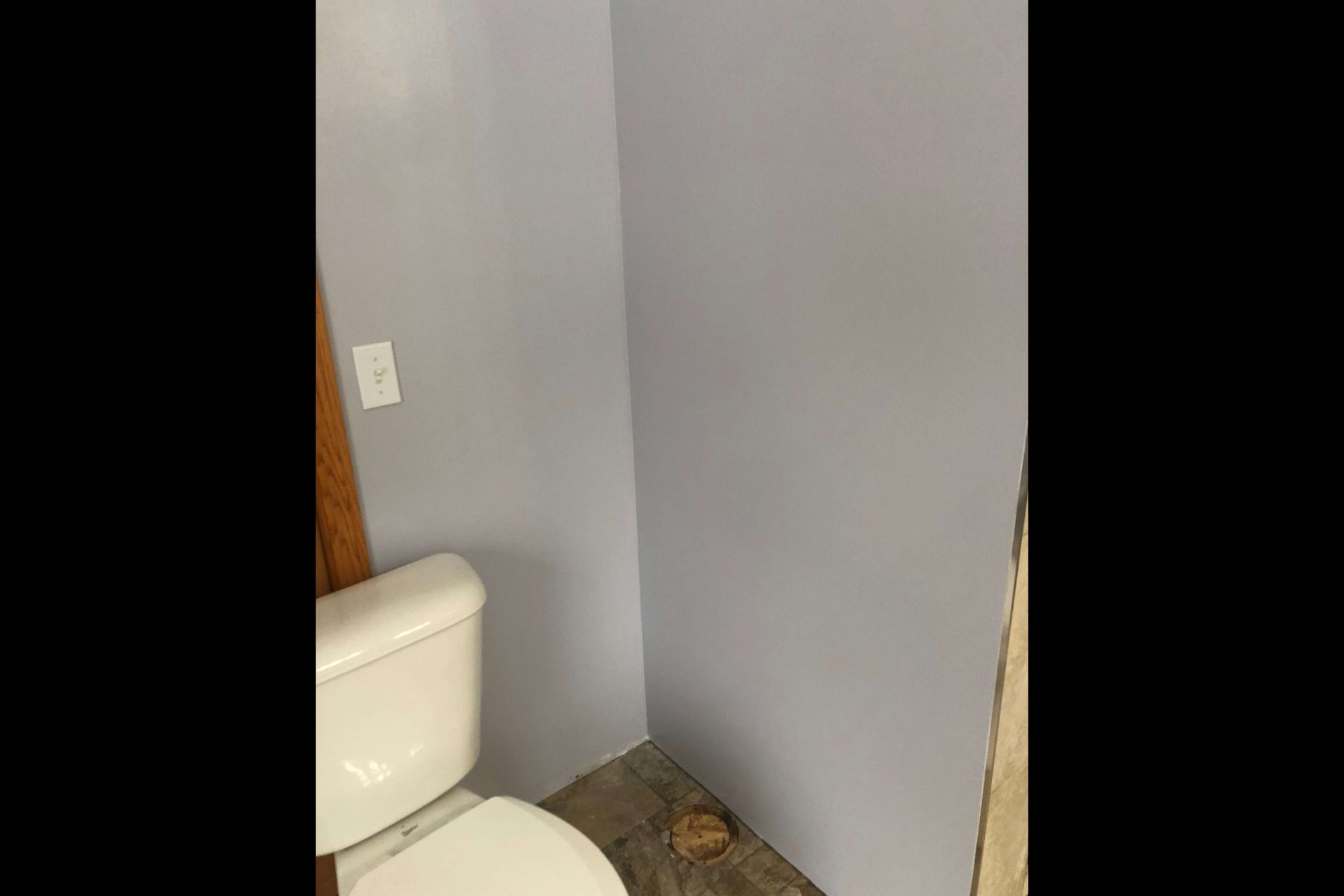 A bathroom with a toilet and a gray wall.