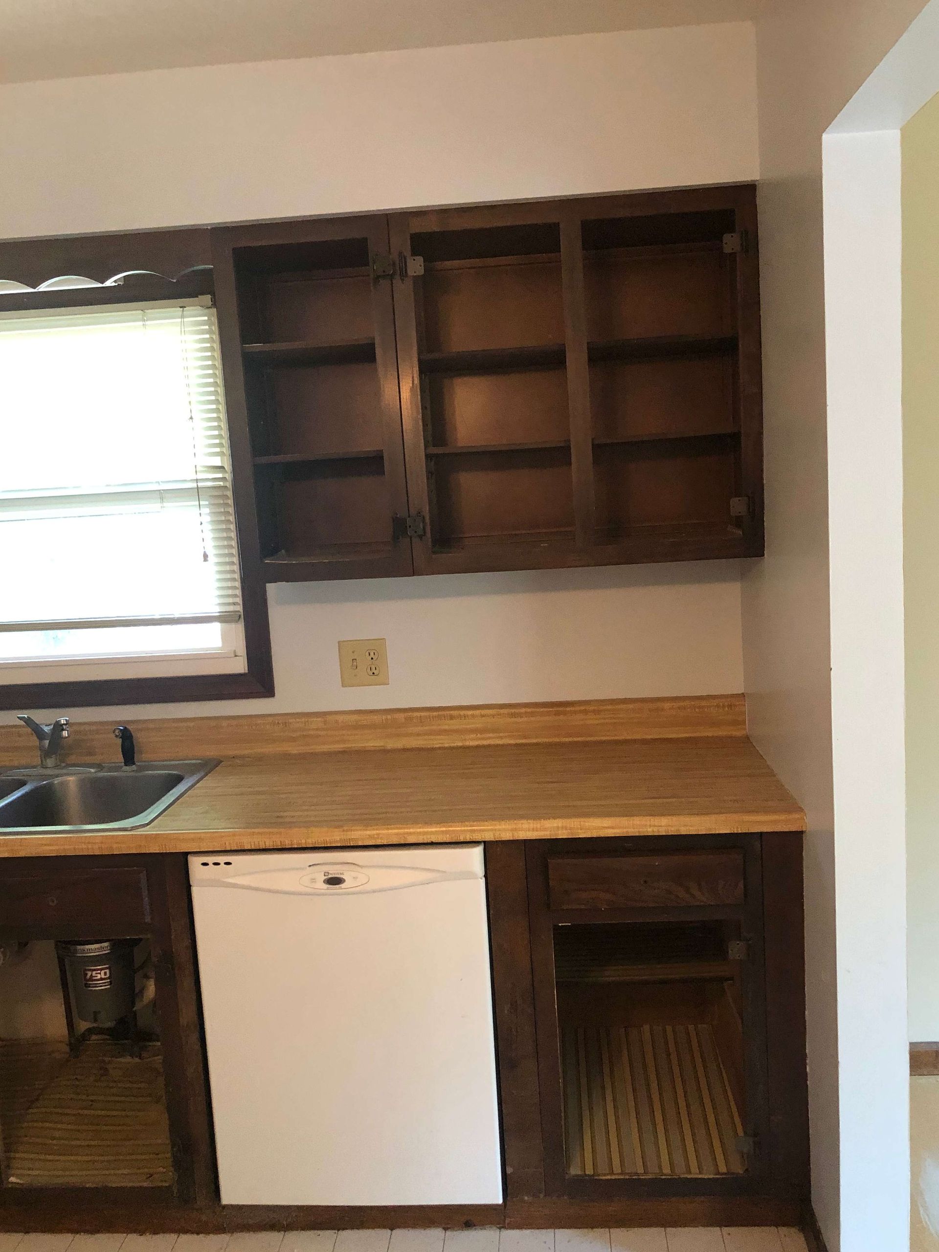 A kitchen with wooden cabinets and a white dishwasher