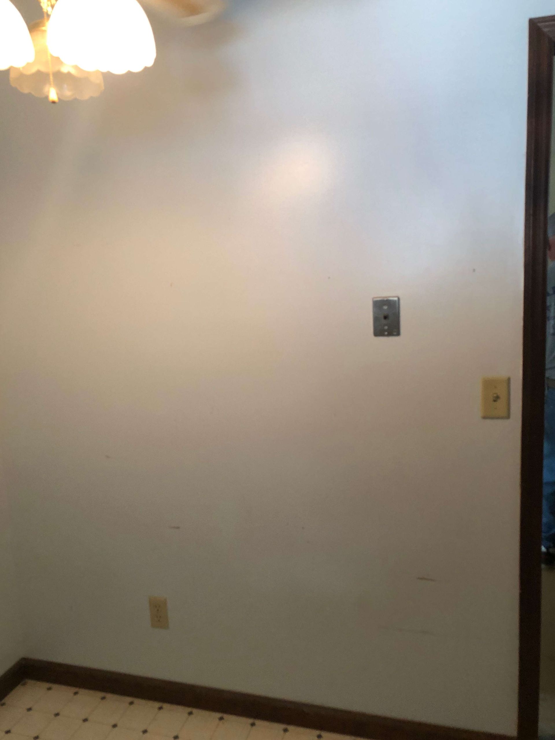 An empty room with a white wall and a door