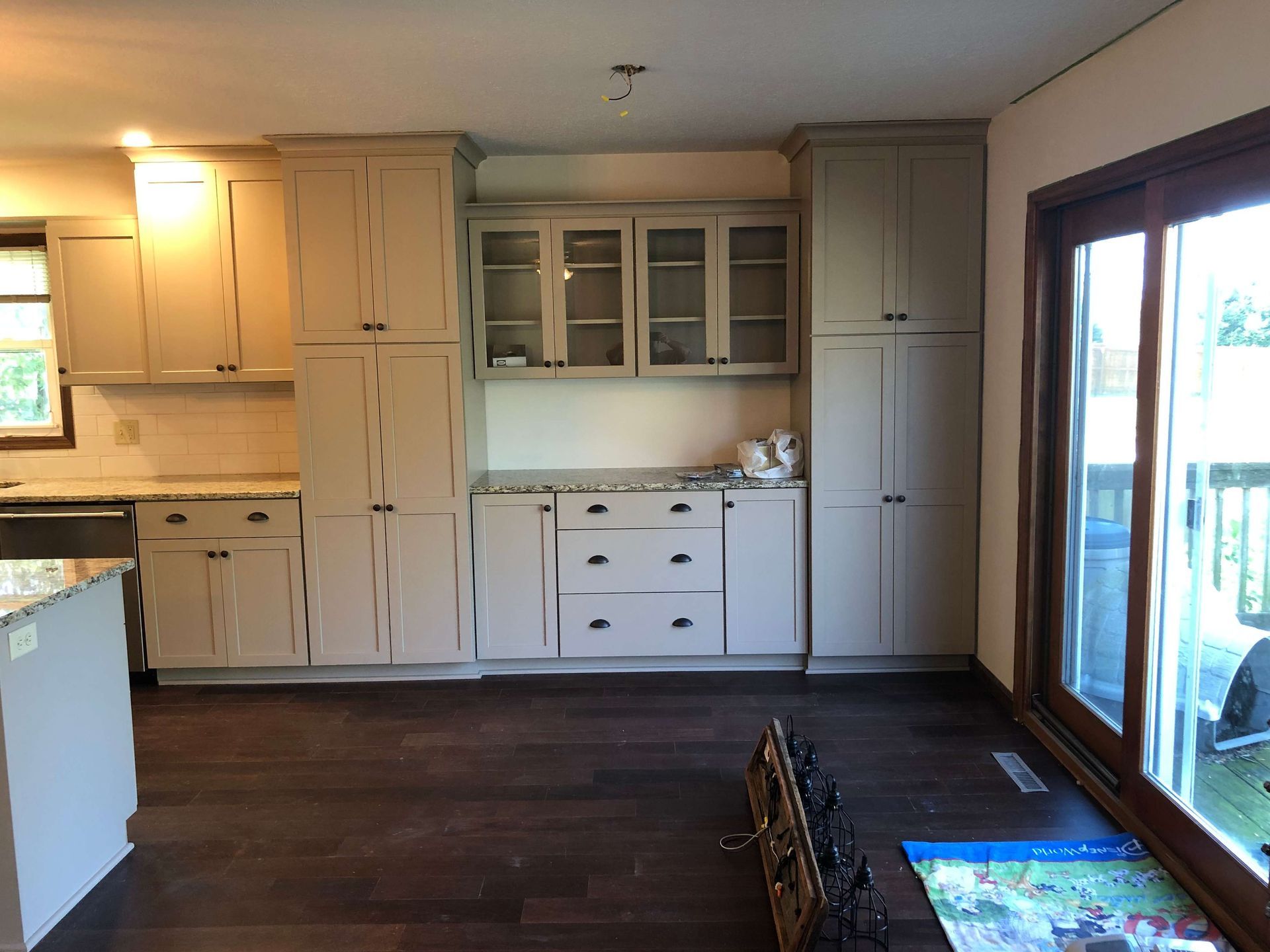 A kitchen with white cabinets and sliding glass doors