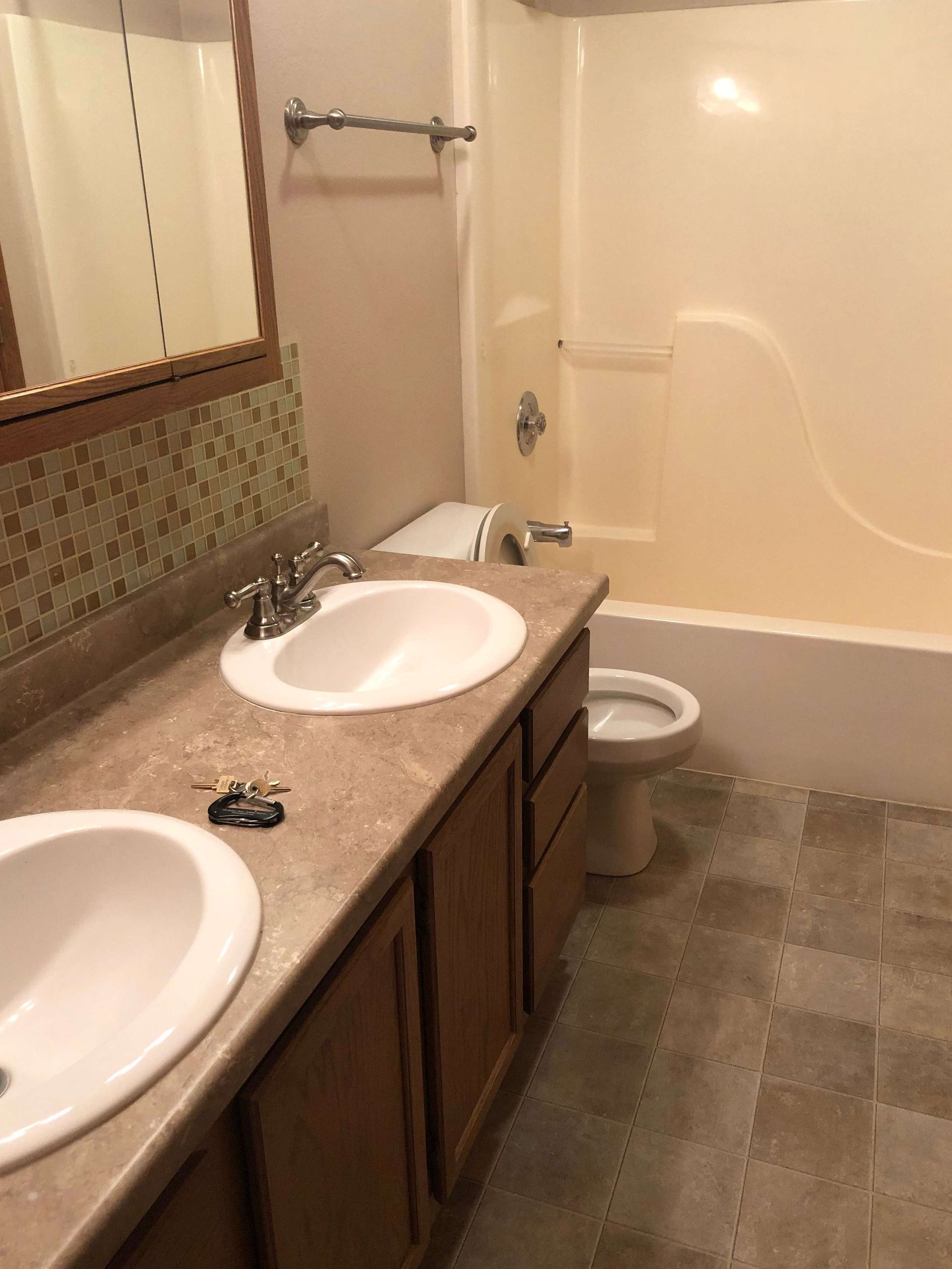 A bathroom with two sinks a toilet and a bathtub