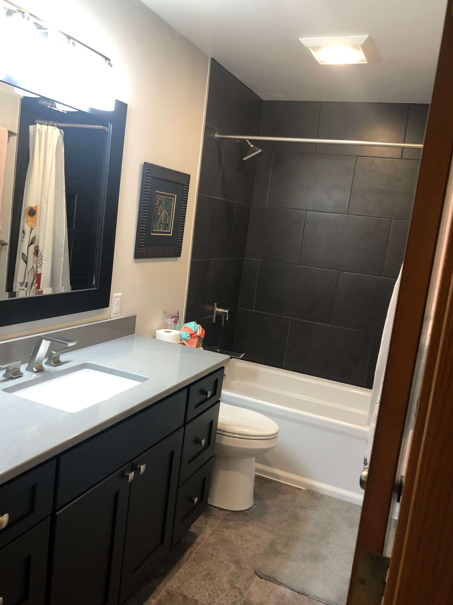 A bathroom with a sink , toilet , bathtub and mirror.