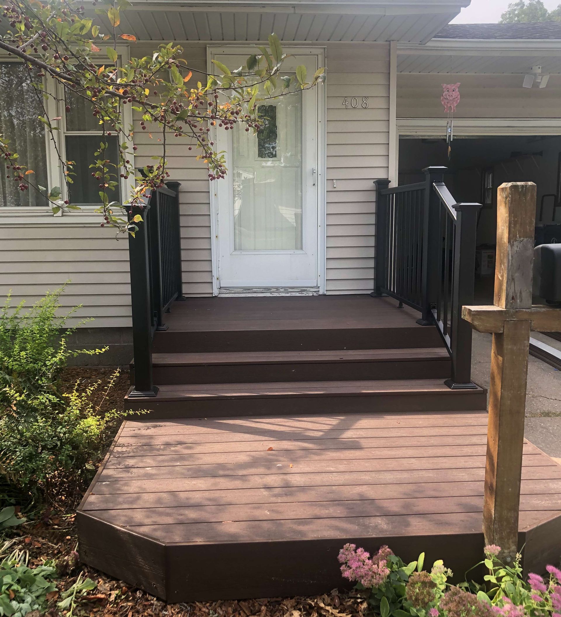 A house with a porch and stairs in front of it.