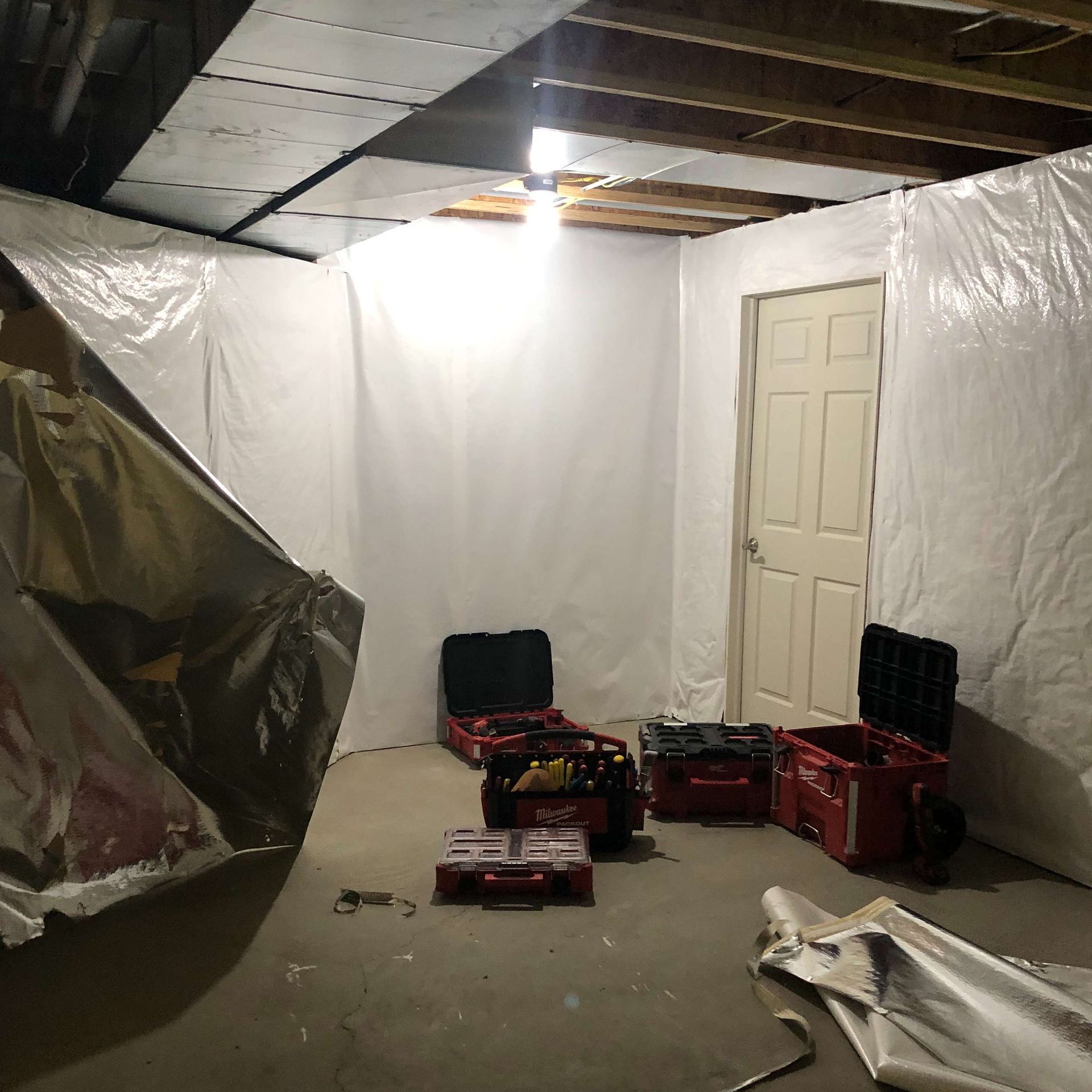 A room with a lot of plastic covering the walls and a door