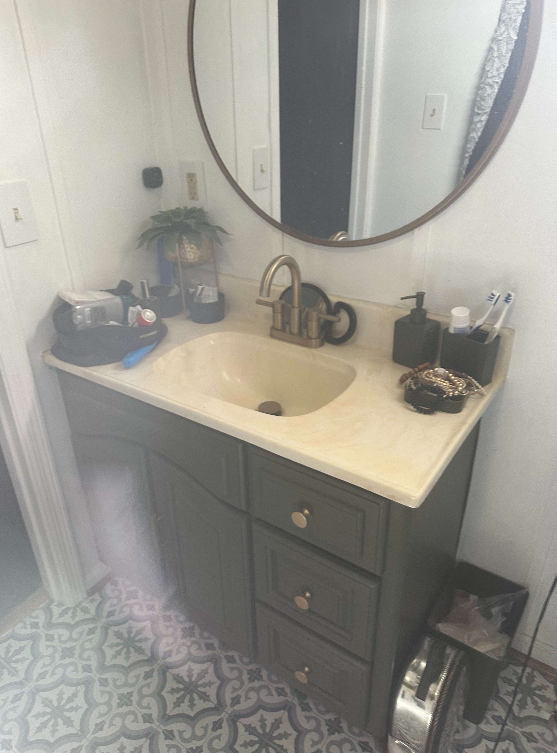 A bathroom vanity with a sink and a mirror.