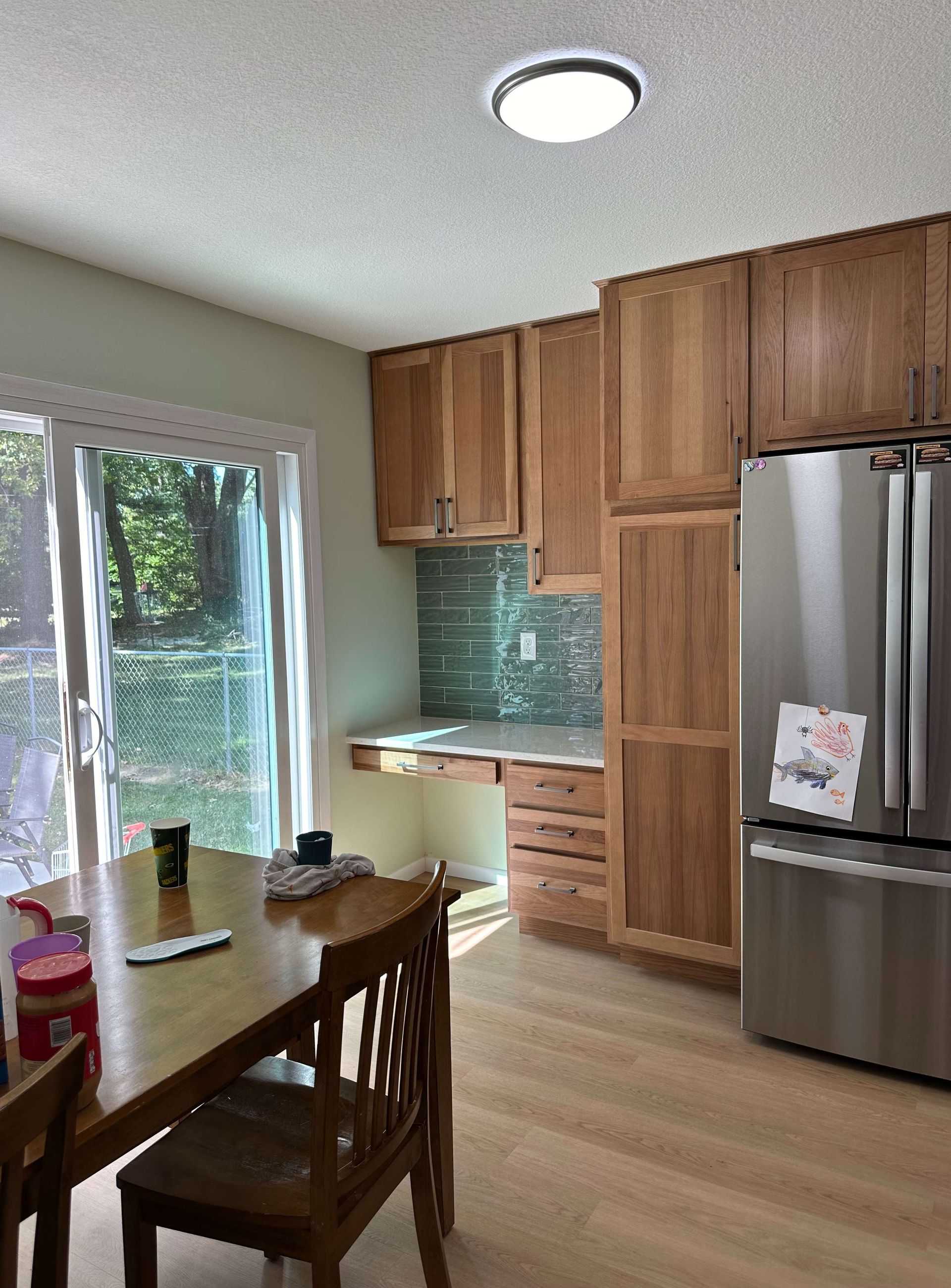 A kitchen with a table and chairs and a refrigerator.