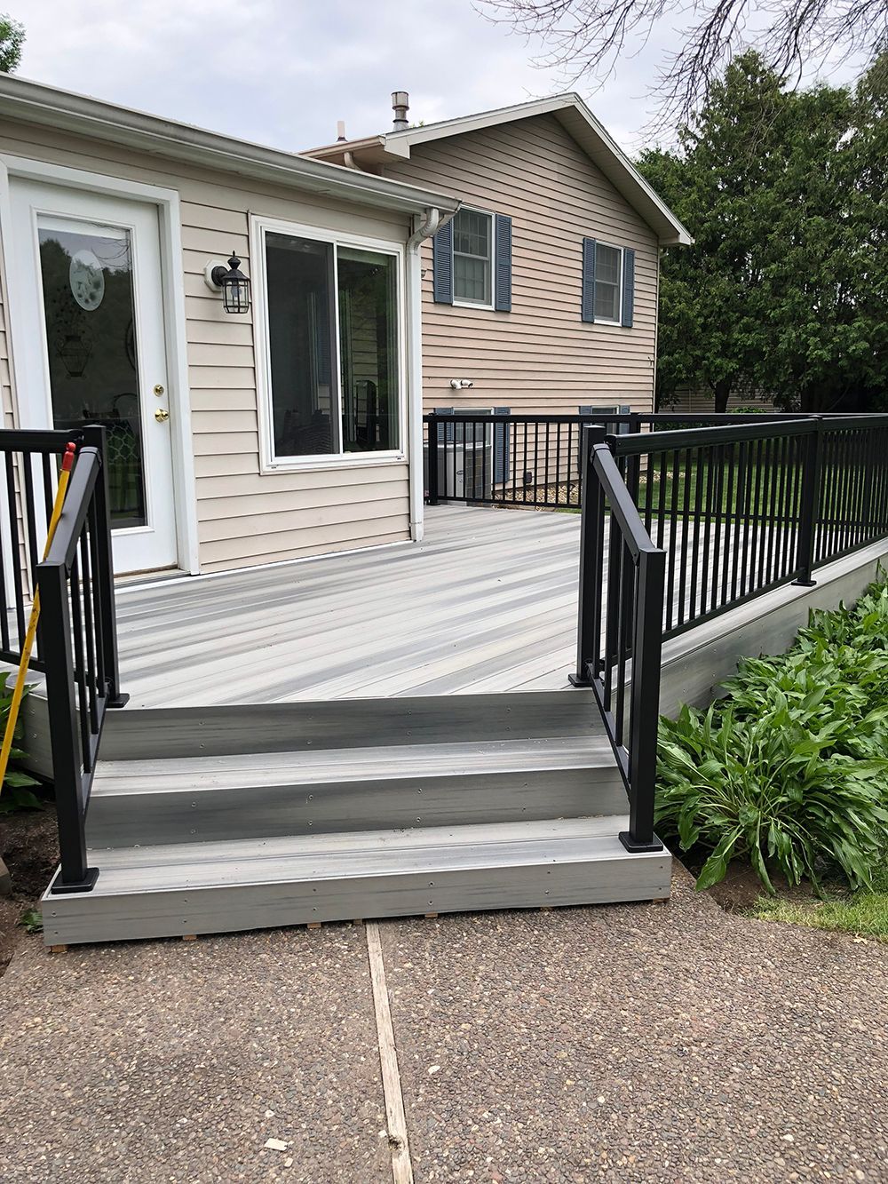 A house with a deck and stairs in front of it.
