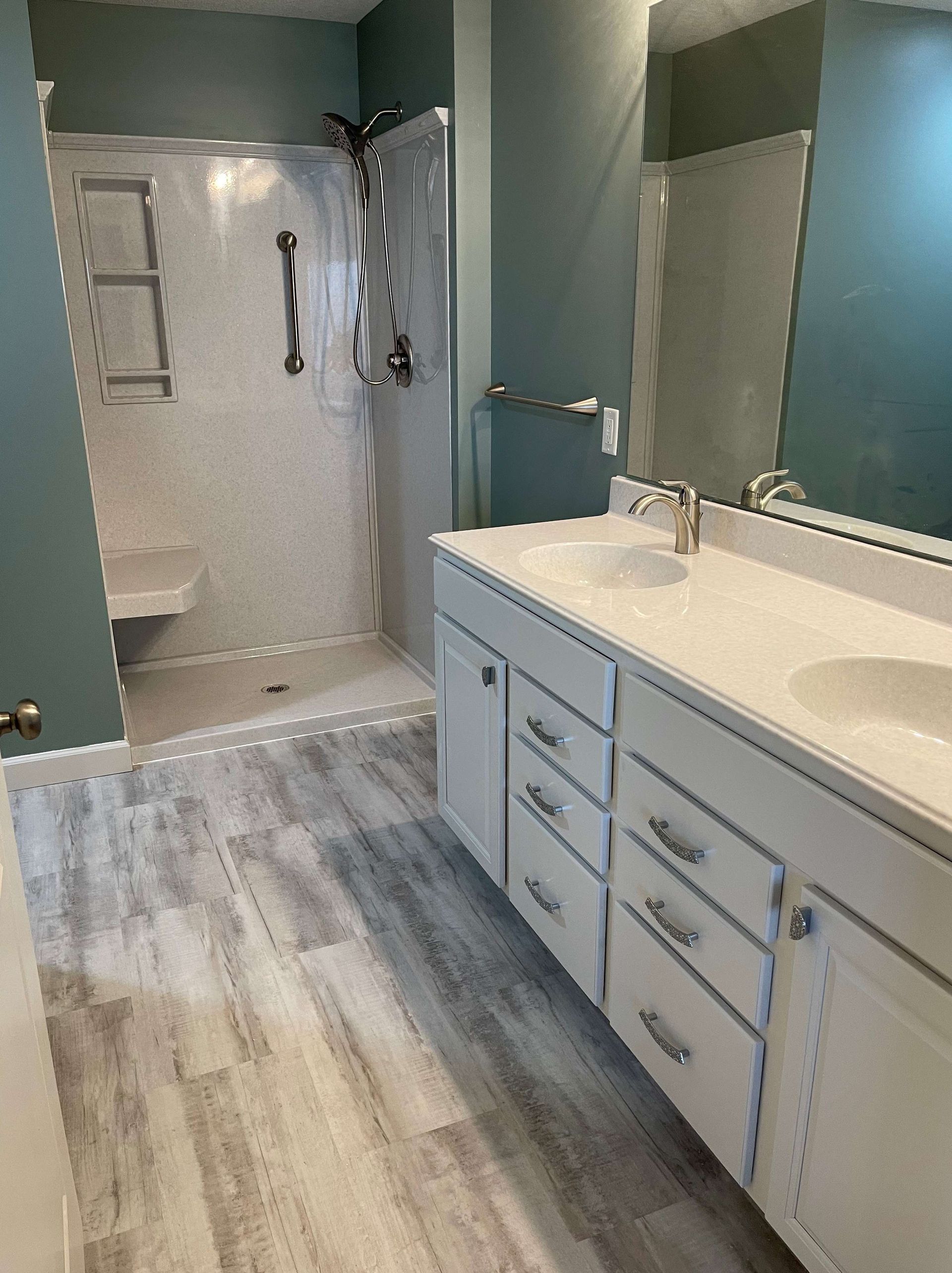 A bathroom with a sink , toilet , shower and mirror.