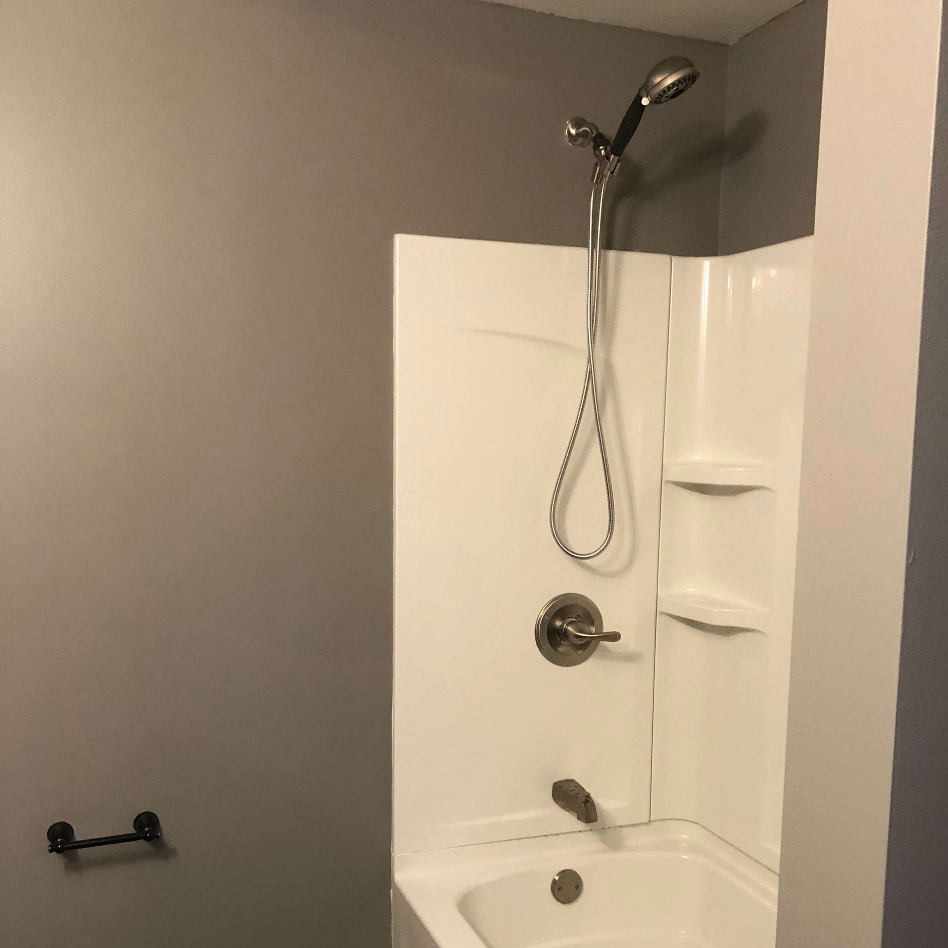 A bathroom with a bathtub and shower with a shower head