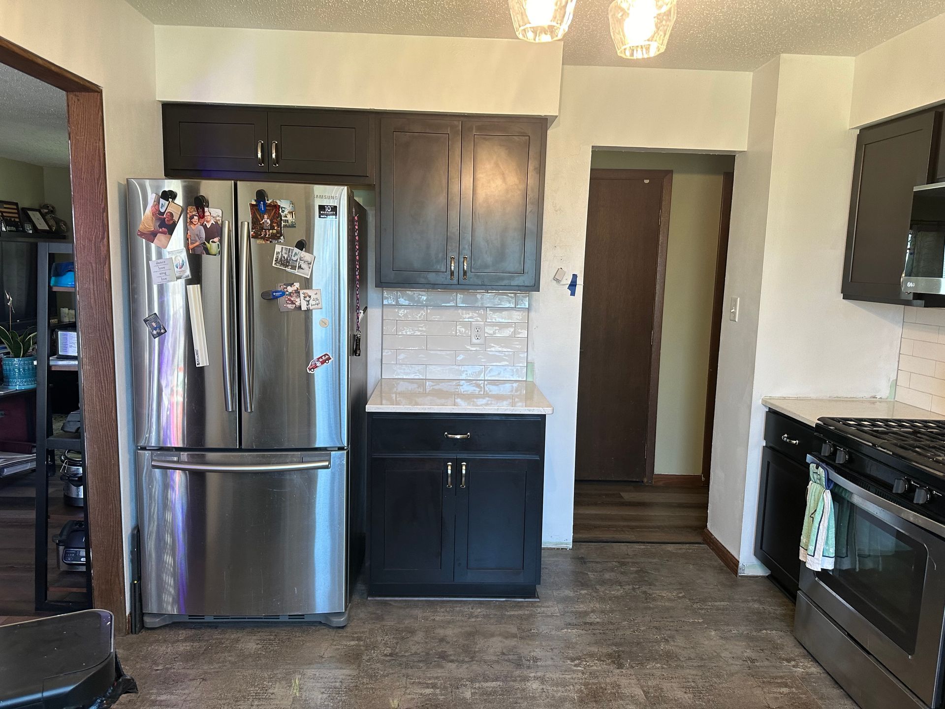 A kitchen with stainless steel appliances and black cabinets