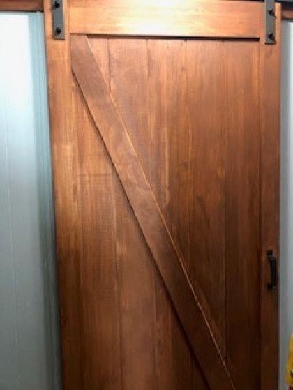 A close up of a wooden sliding barn door in a room.