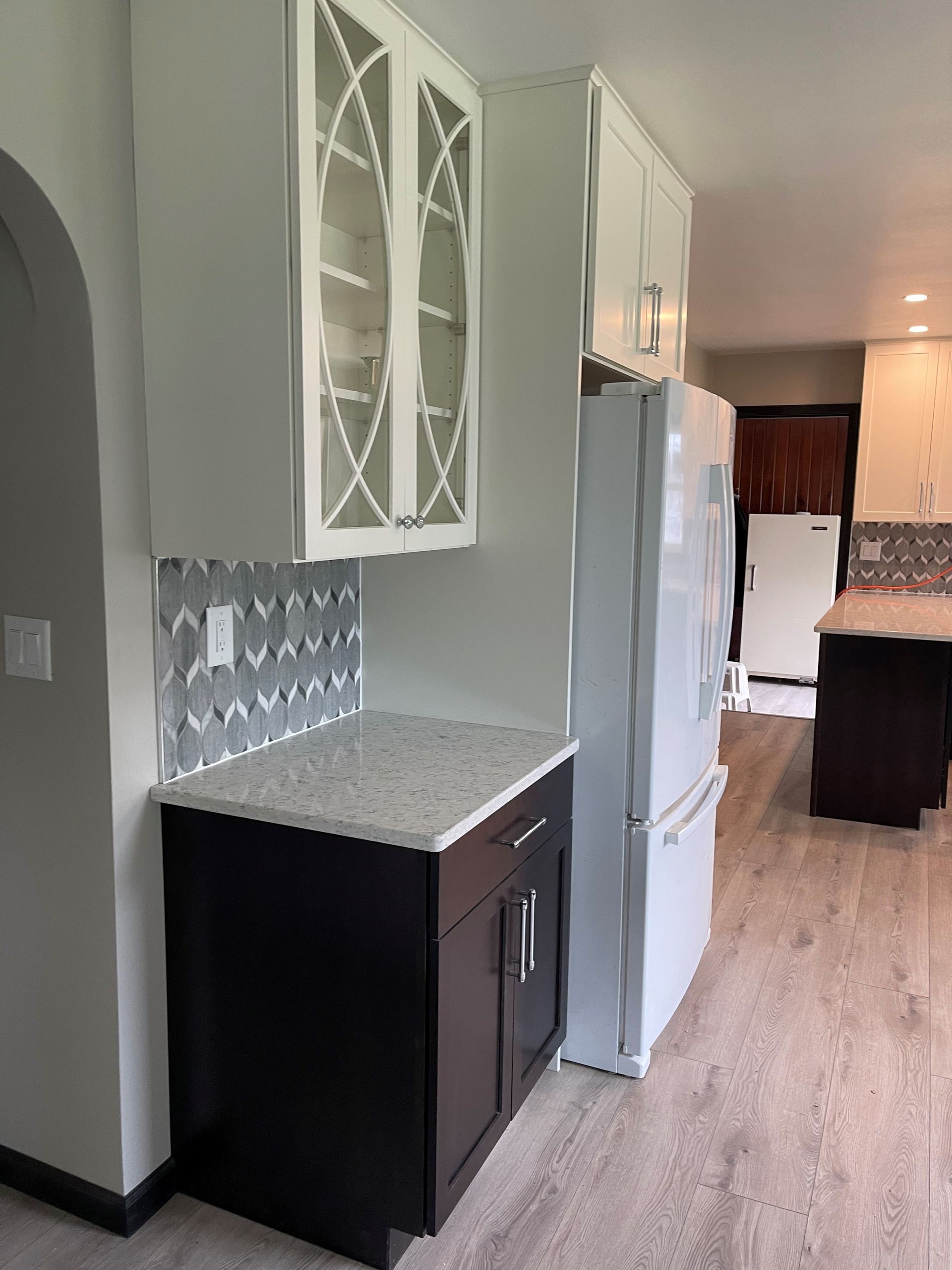 A kitchen with a refrigerator , sink , and cabinets.
