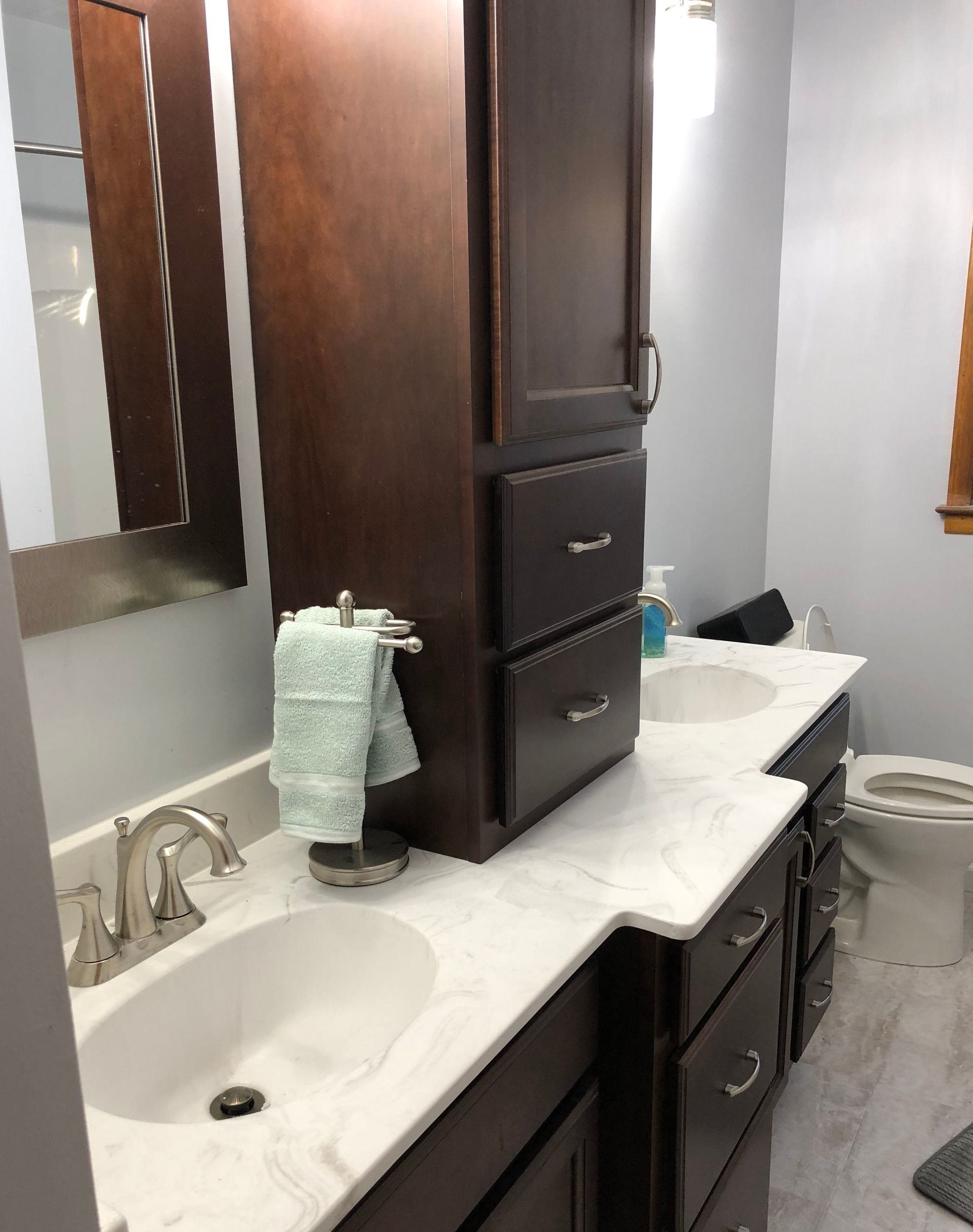A bathroom with two sinks and a toilet