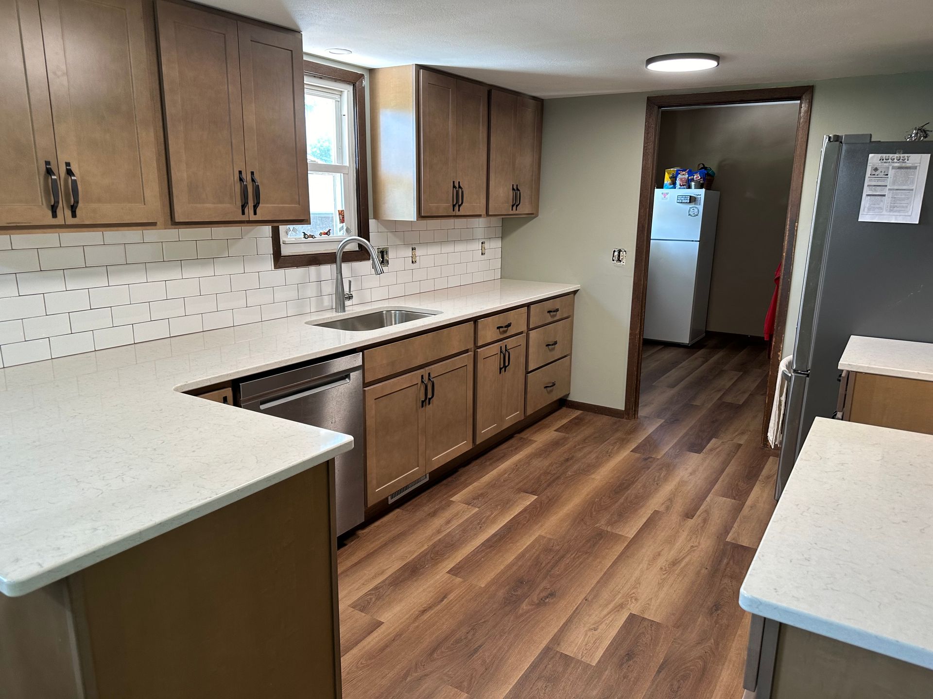 A kitchen with wooden cabinets and white counter tops