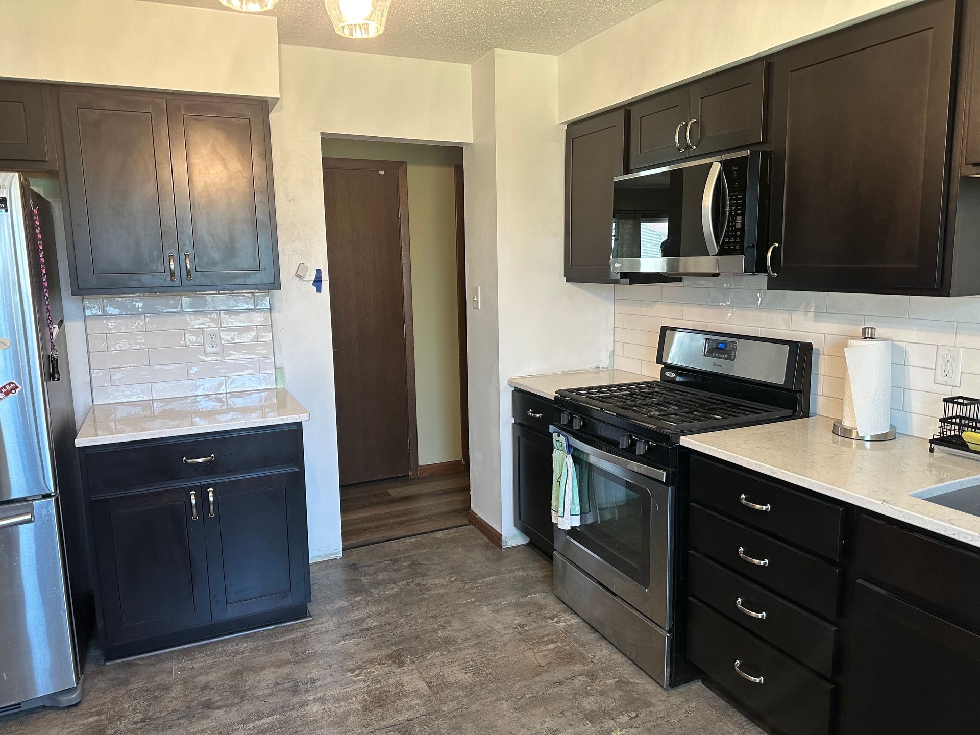 A kitchen with black cabinets and stainless steel appliances