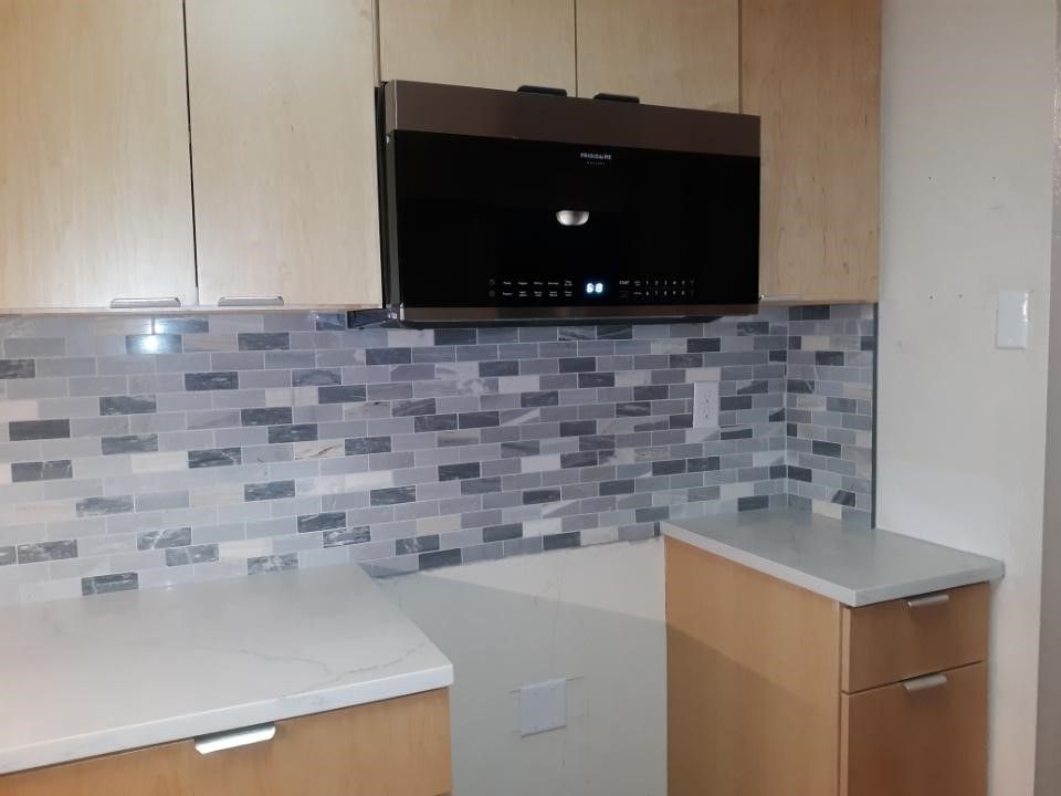 A kitchen with wooden cabinets and a microwave.