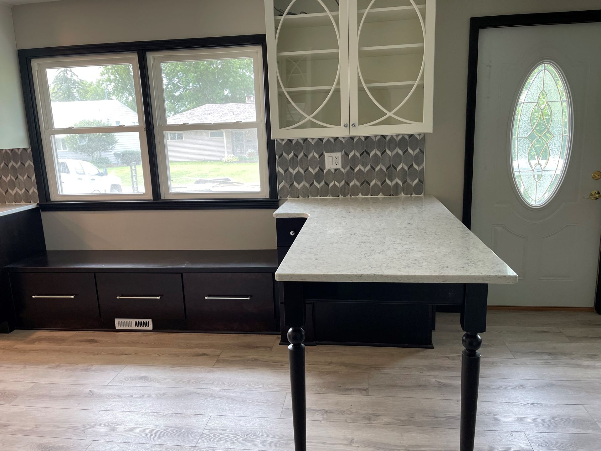 A kitchen with a table and cabinets and a window