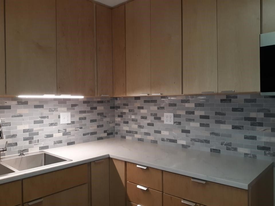 A kitchen with wooden cabinets and a stainless steel sink