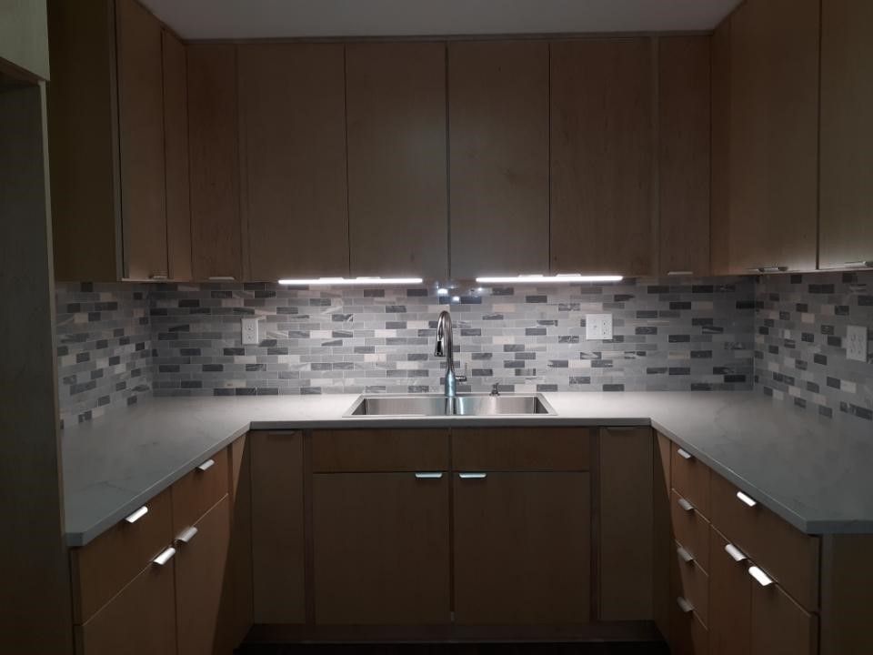 A kitchen with wooden cabinets and a stainless steel sink