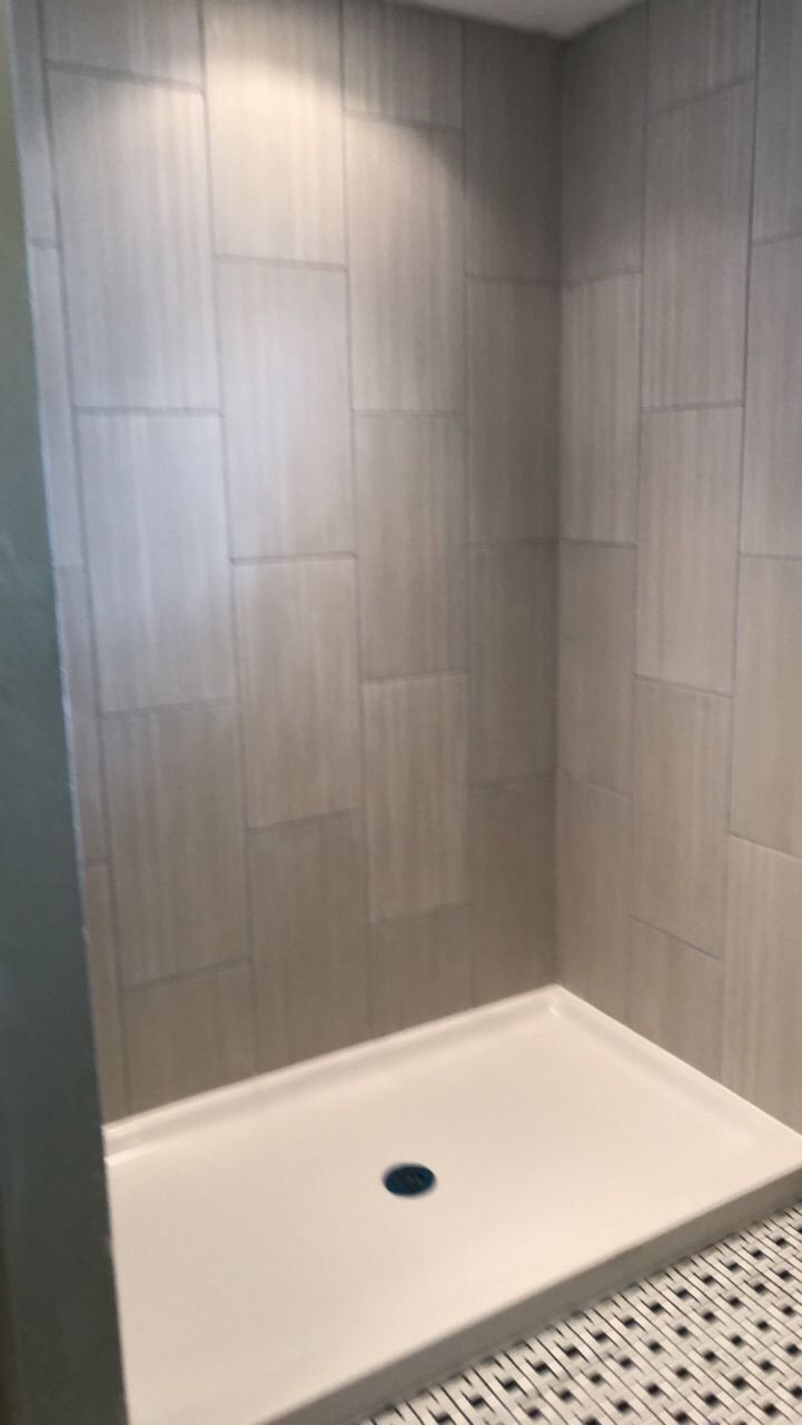 A bathroom with a walk in shower and tiled walls.