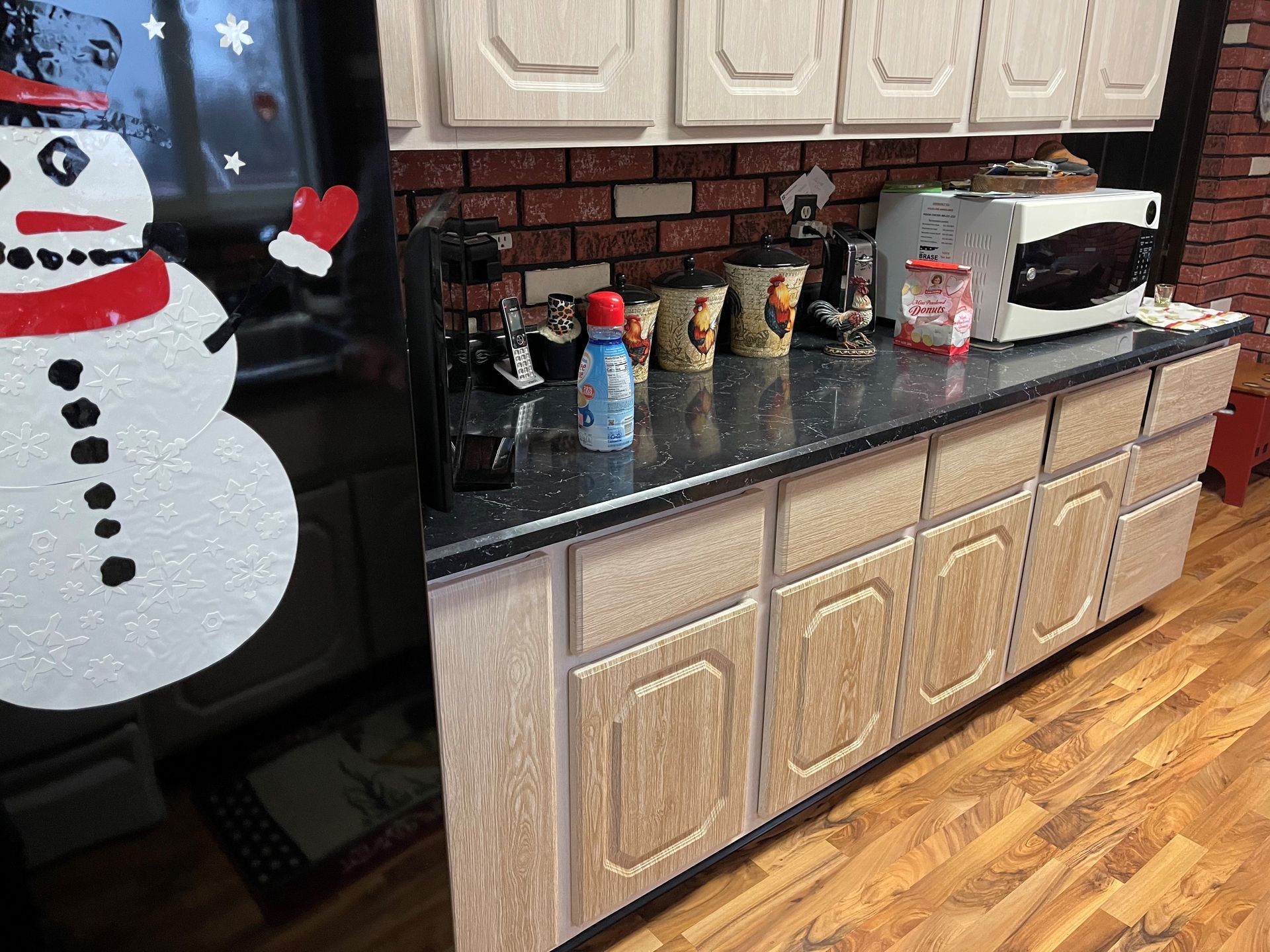 A kitchen with a snowman on the refrigerator door