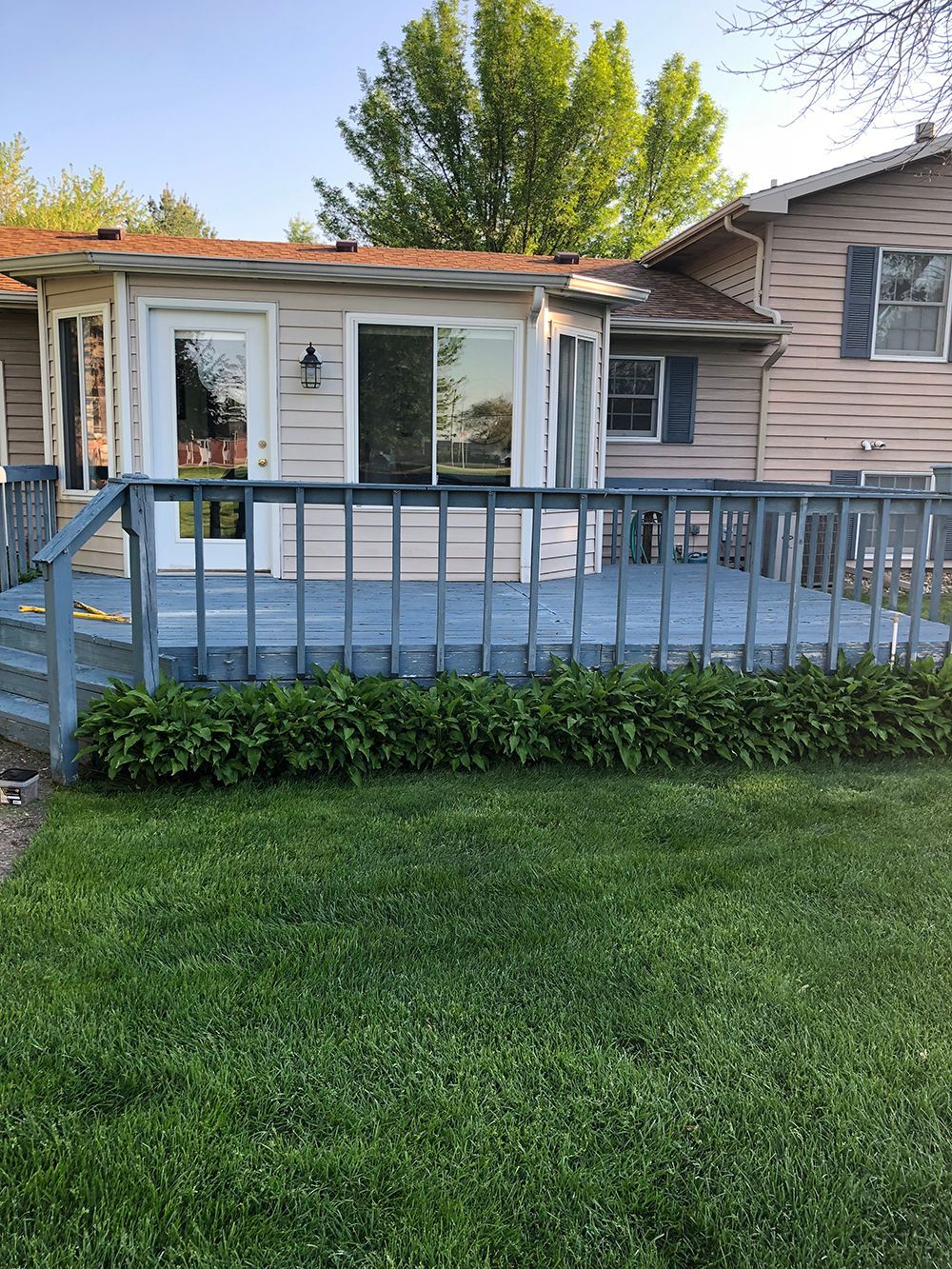 A small house with a large deck in front of it.