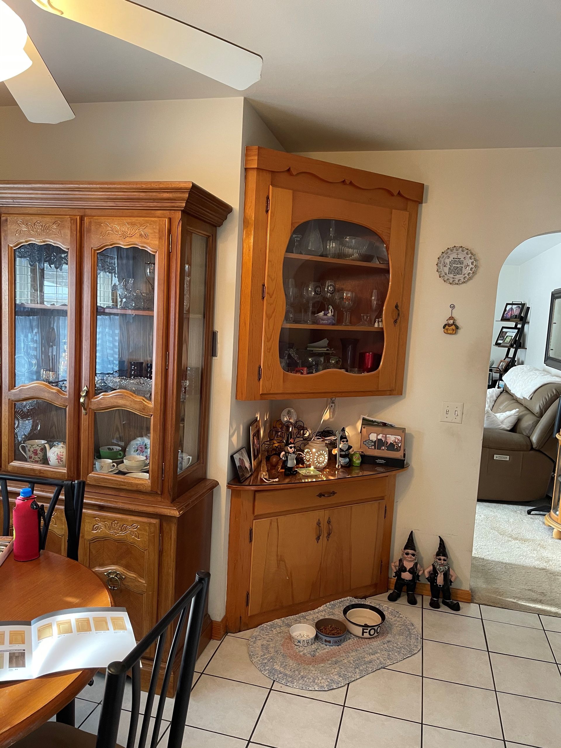 A dining room with a hutch and a table and chairs