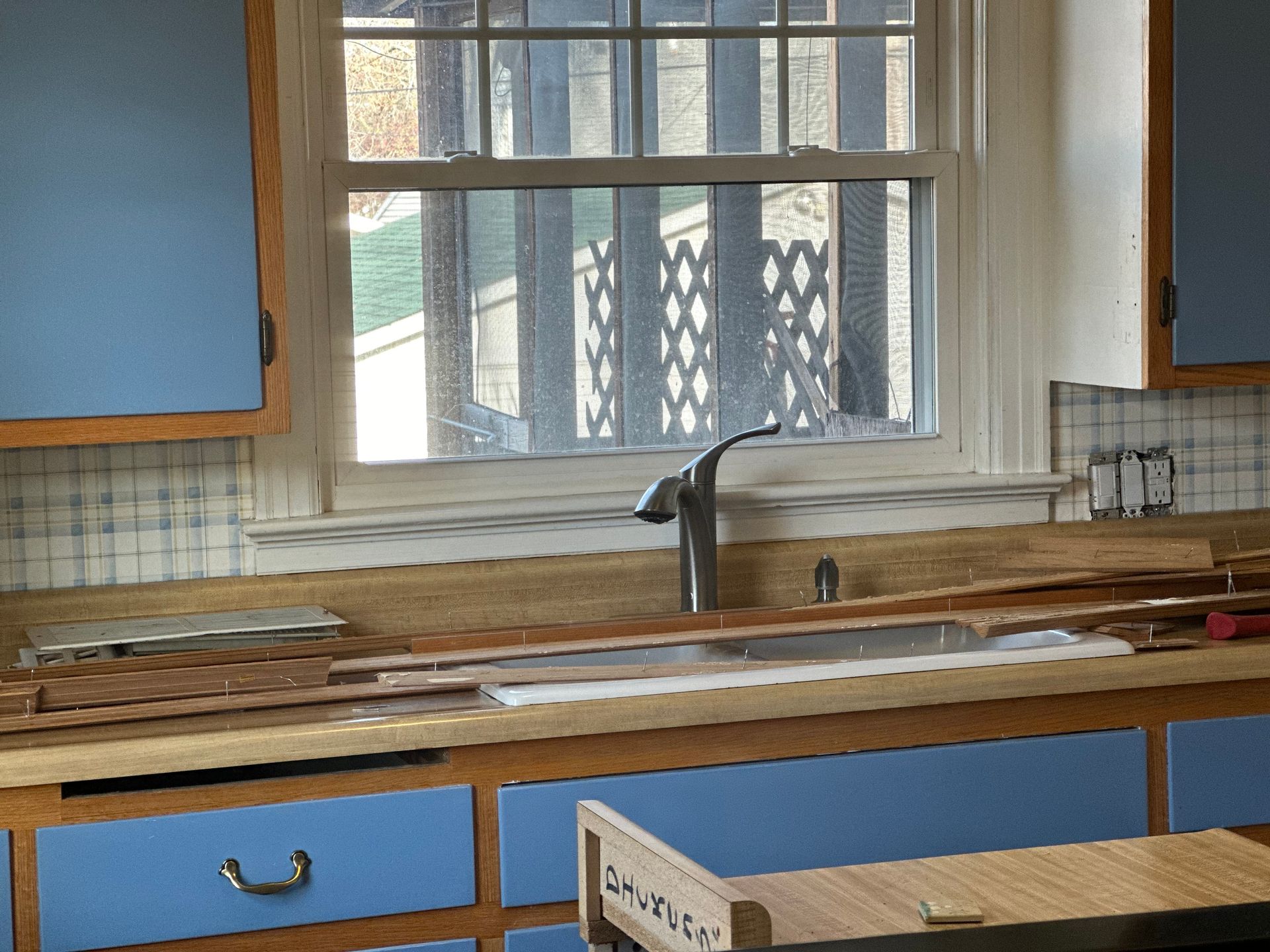 A kitchen with blue cabinets a sink and a window