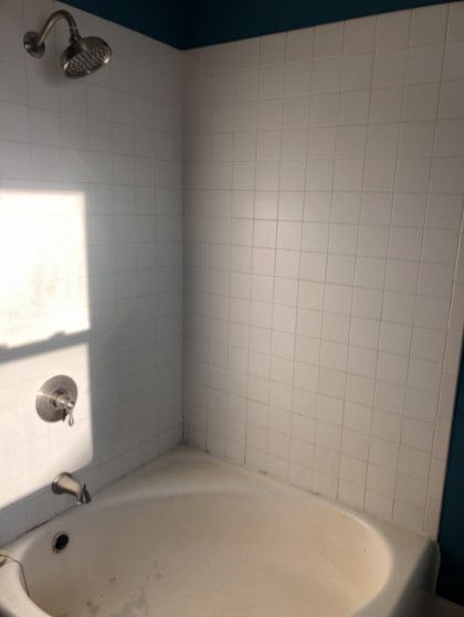 A bathroom with a bathtub and a shower.