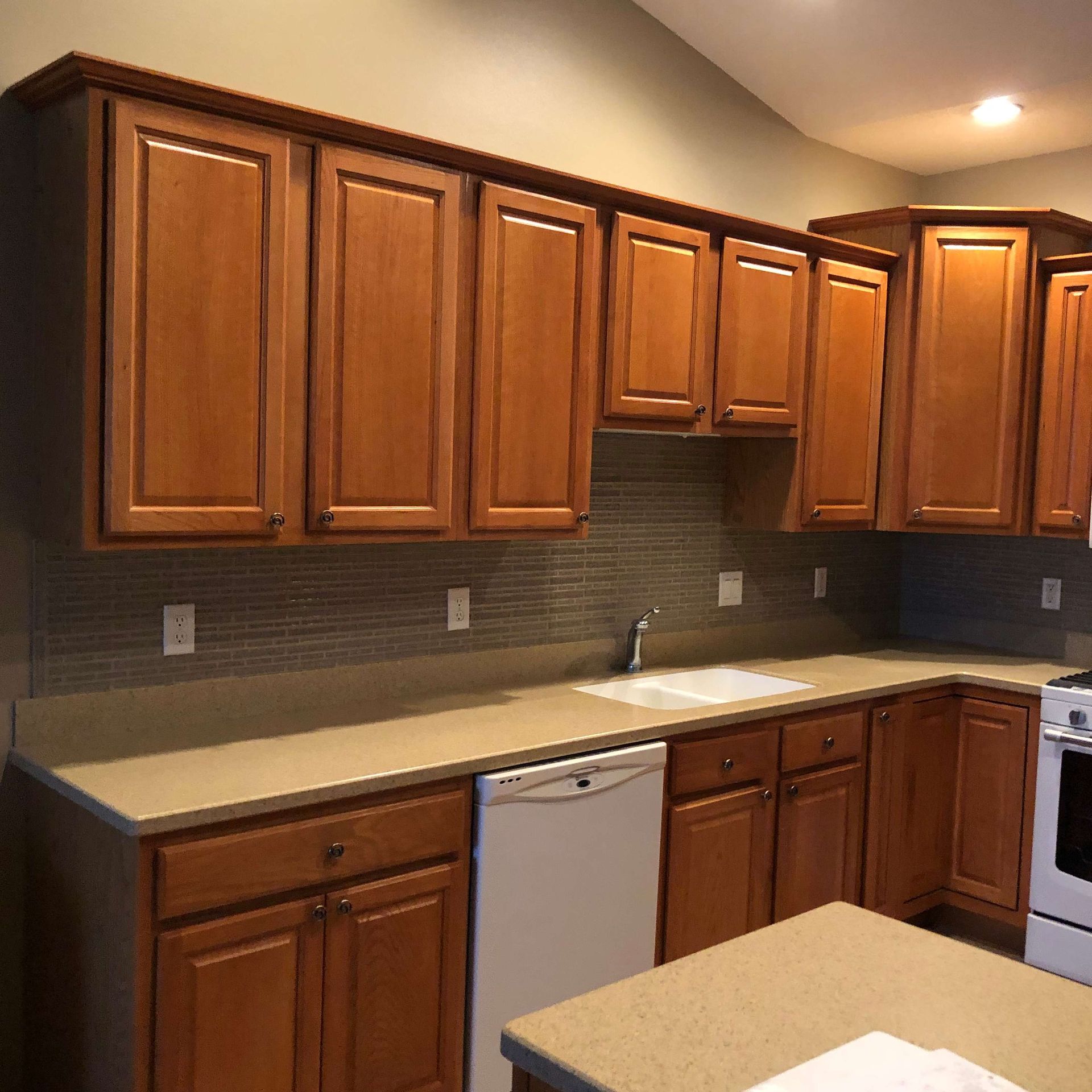 A kitchen with wooden cabinets and a white dishwasher