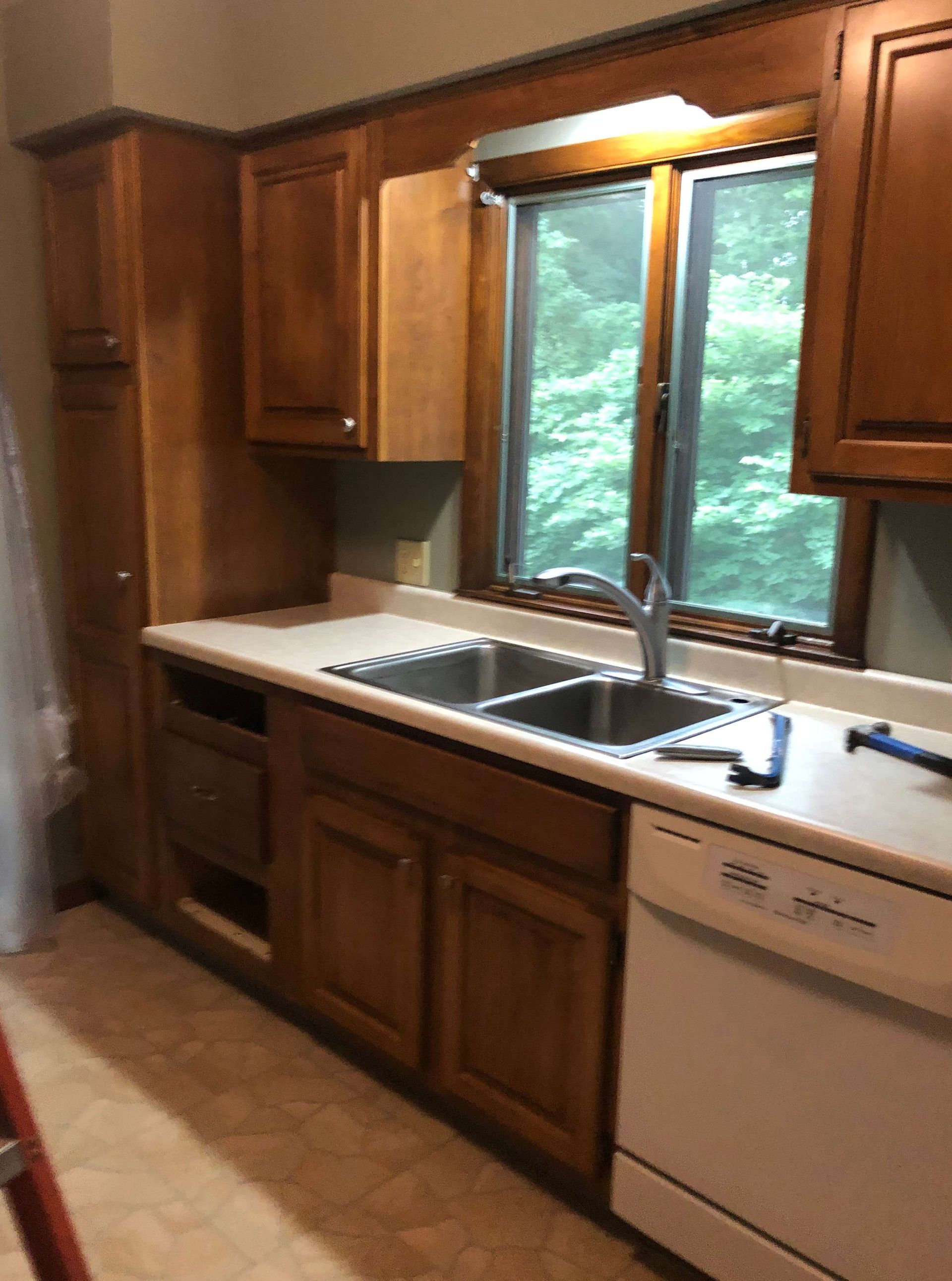 A kitchen with two sinks , a dishwasher , and a window.