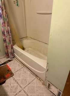 A bathroom with a bathtub and shower stall.