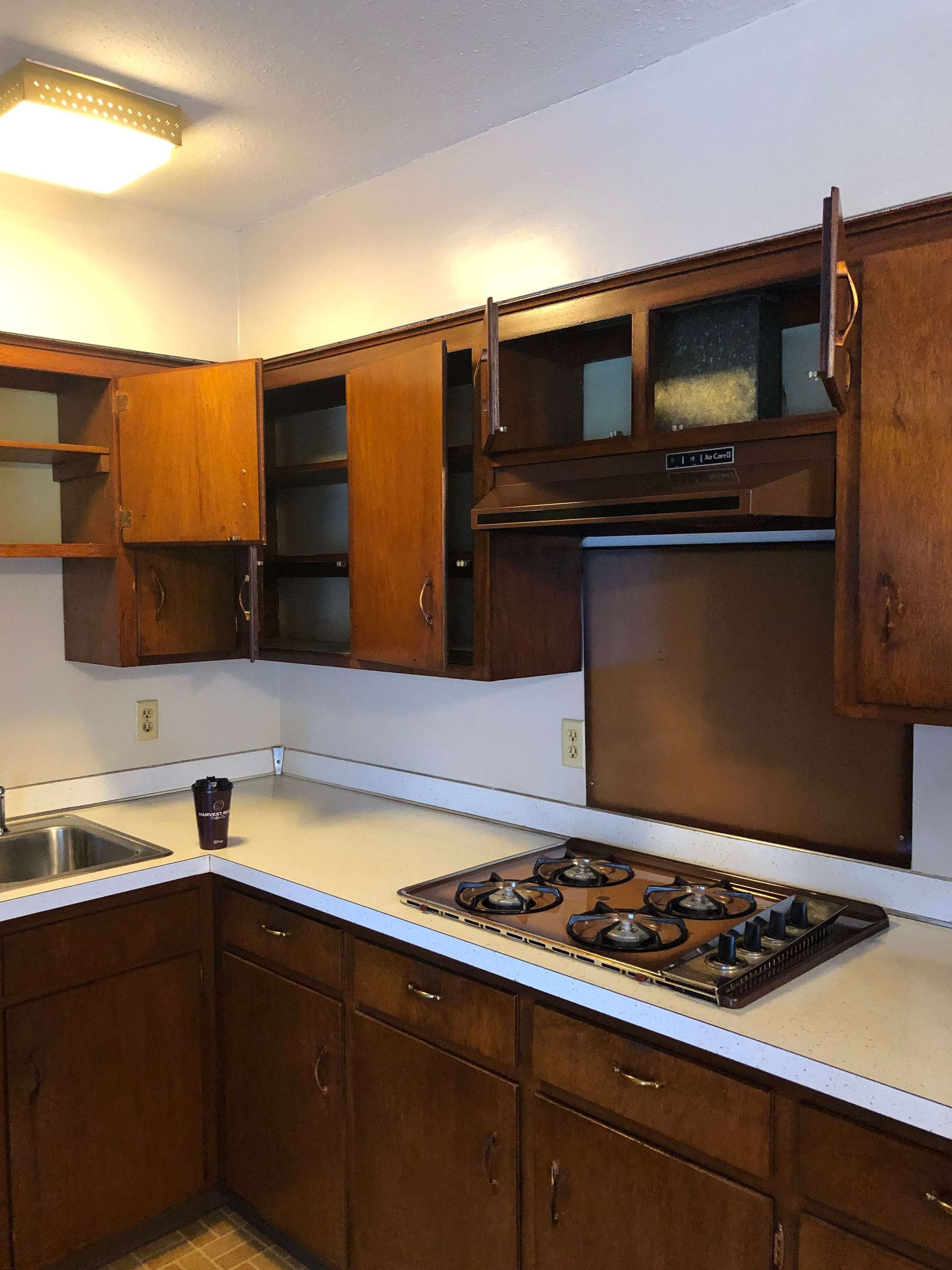 A kitchen with wooden cabinets and a stove top oven