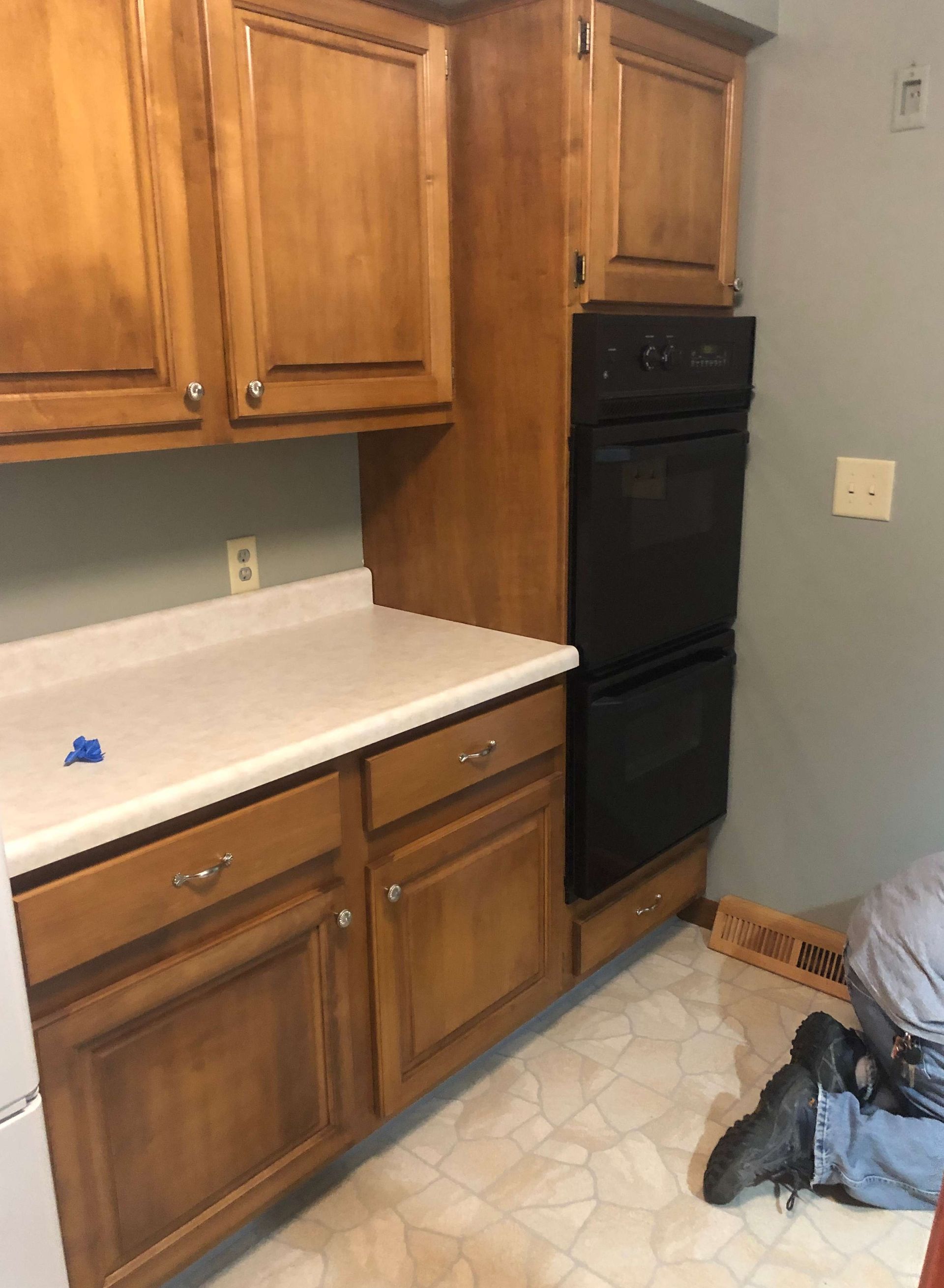 A kitchen with wooden cabinets and a black oven