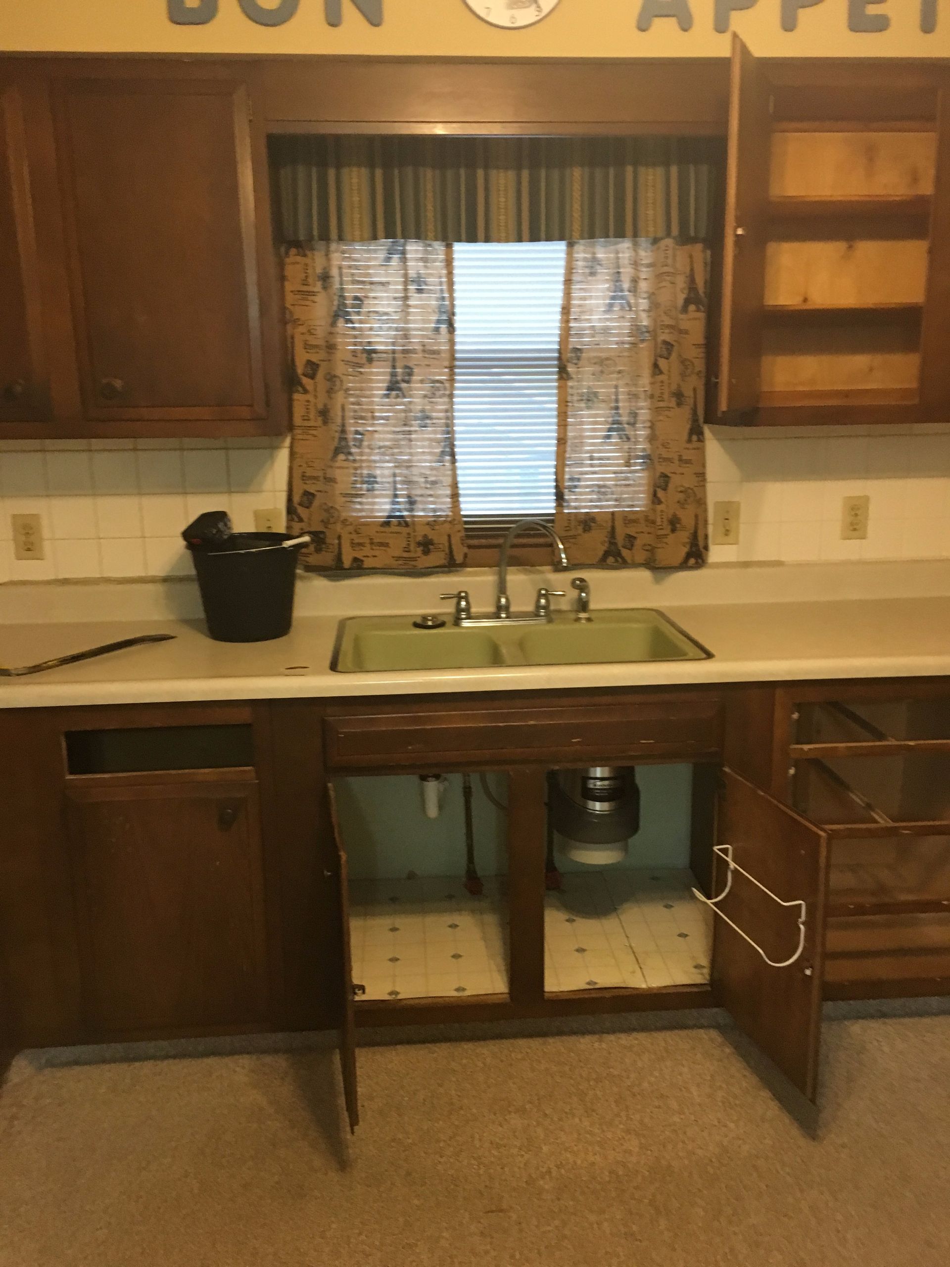 A kitchen with the word bon appet above the sink