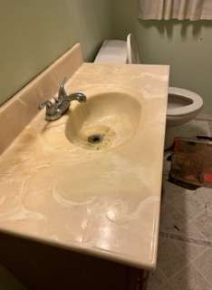A bathroom sink with a toilet in the background.