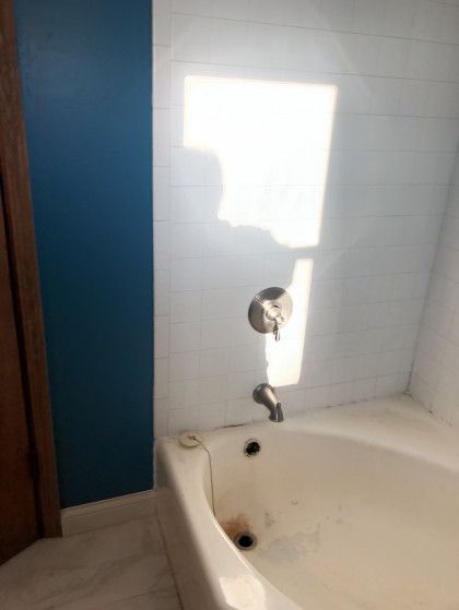 A bathtub in a bathroom with a blue wall
