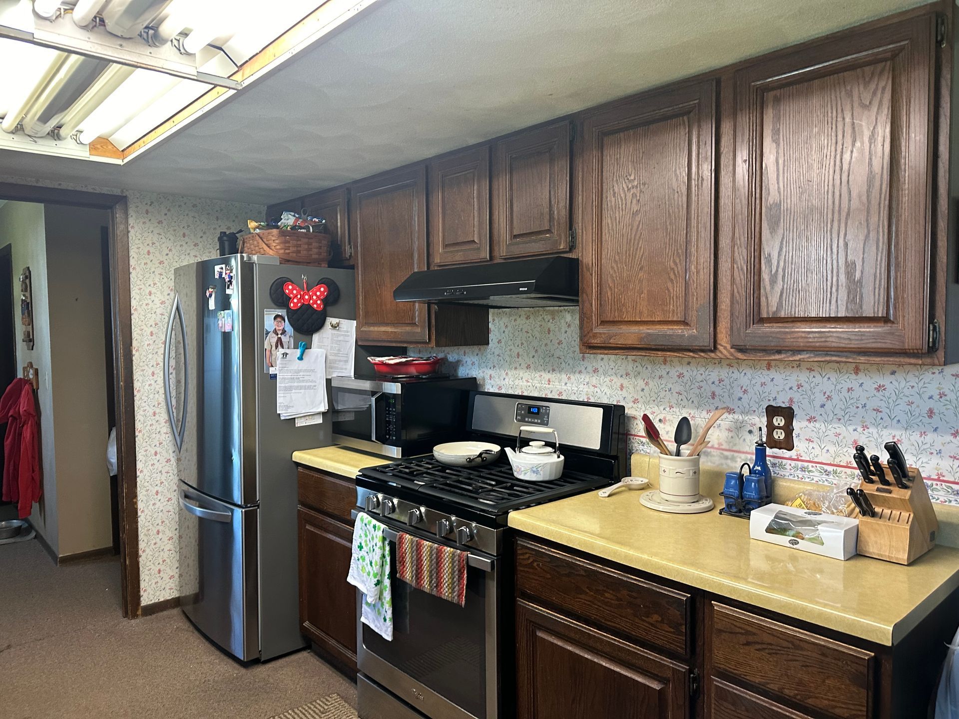 A kitchen with stainless steel appliances and wooden cabinets