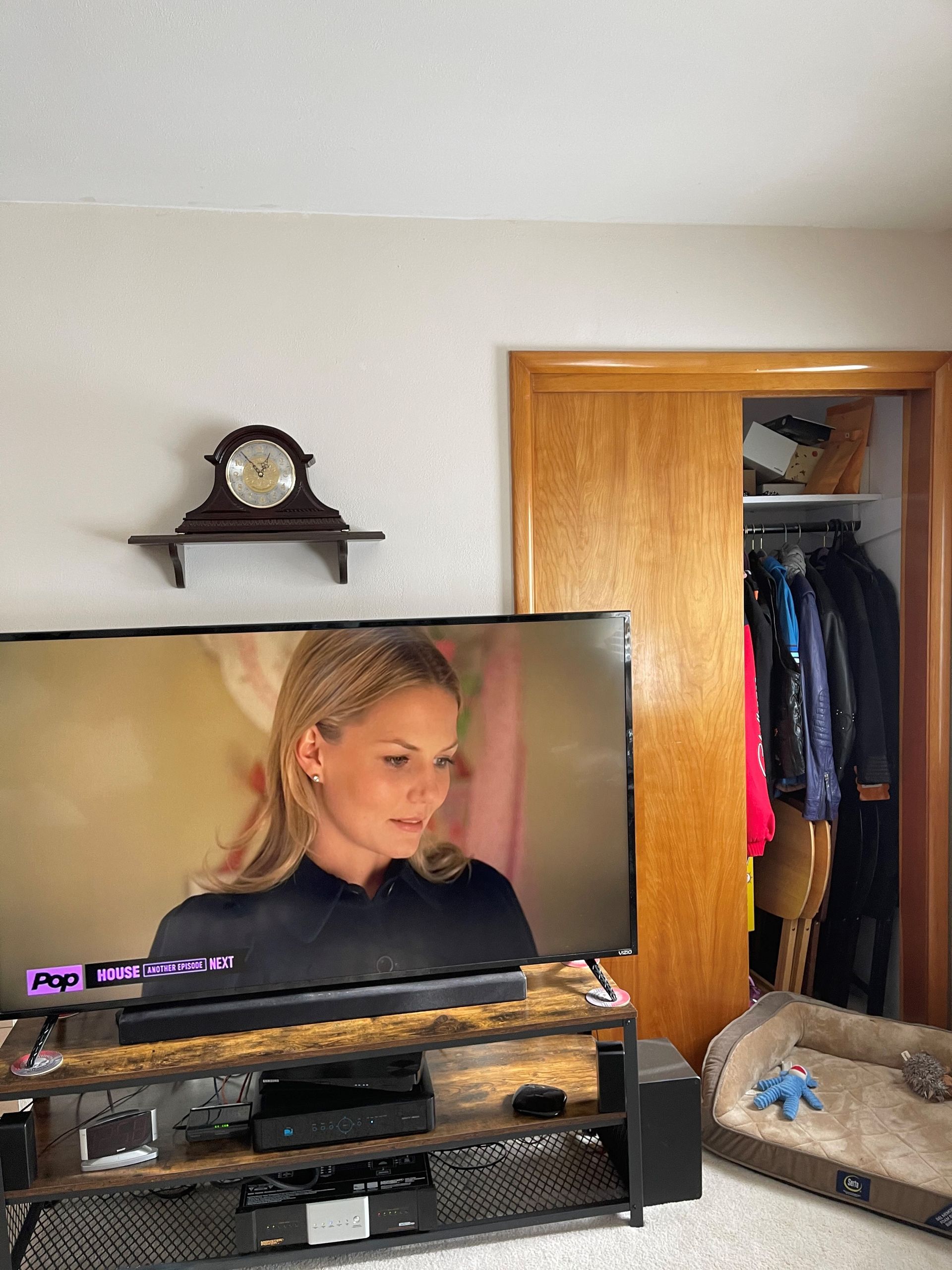 A woman is sitting in front of a television in a living room.
