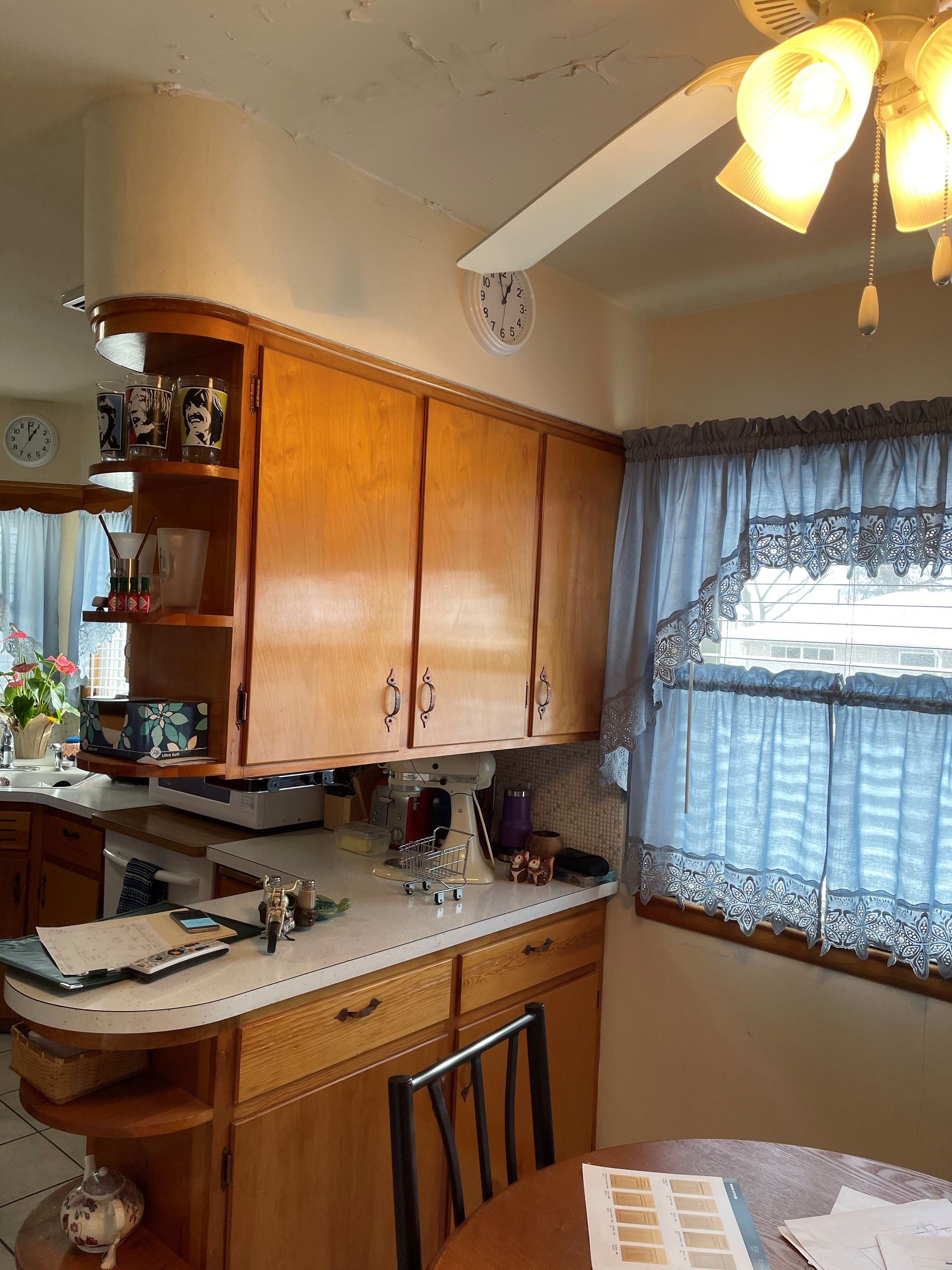 A kitchen with wooden cabinets and a ceiling fan